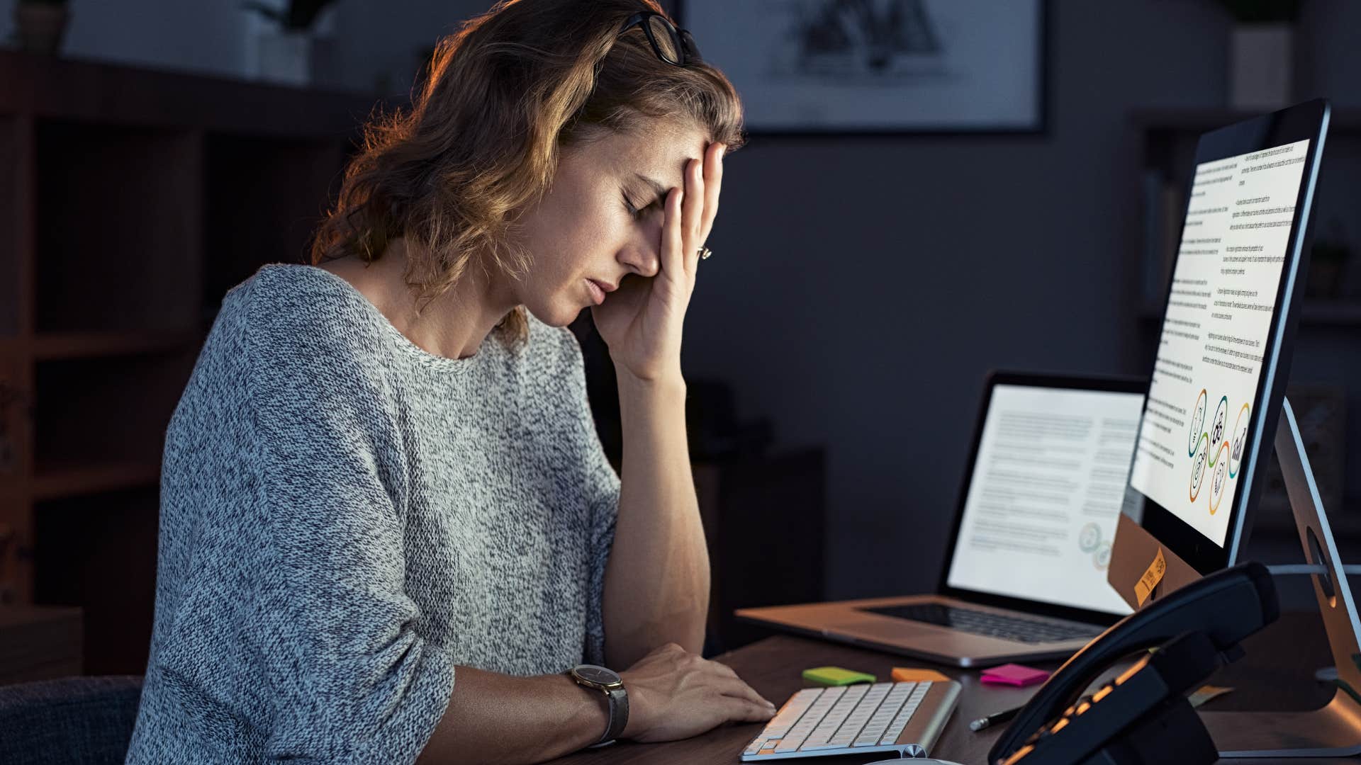 tired woman working overtime on her laptop