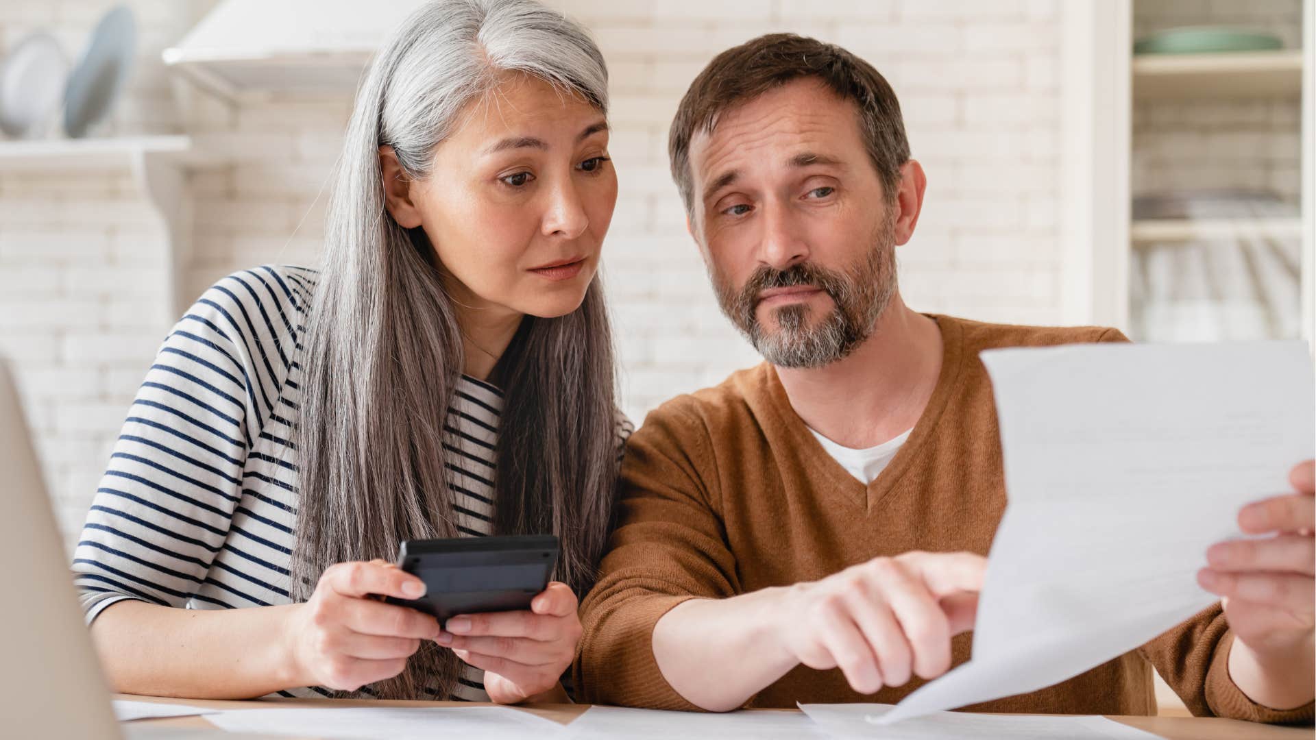Couple receiving government assistance and reading a letter.