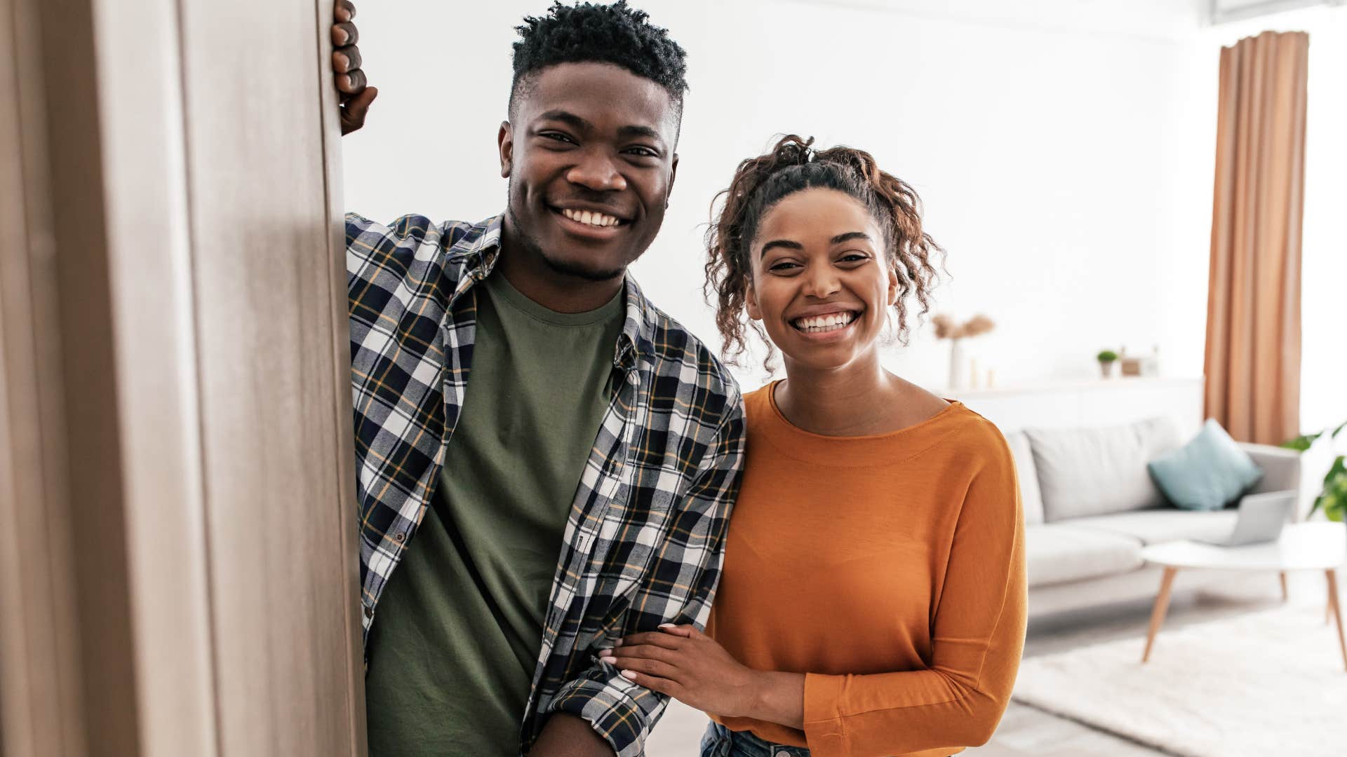 financially stressed couple smiling saying we're doing better than most people