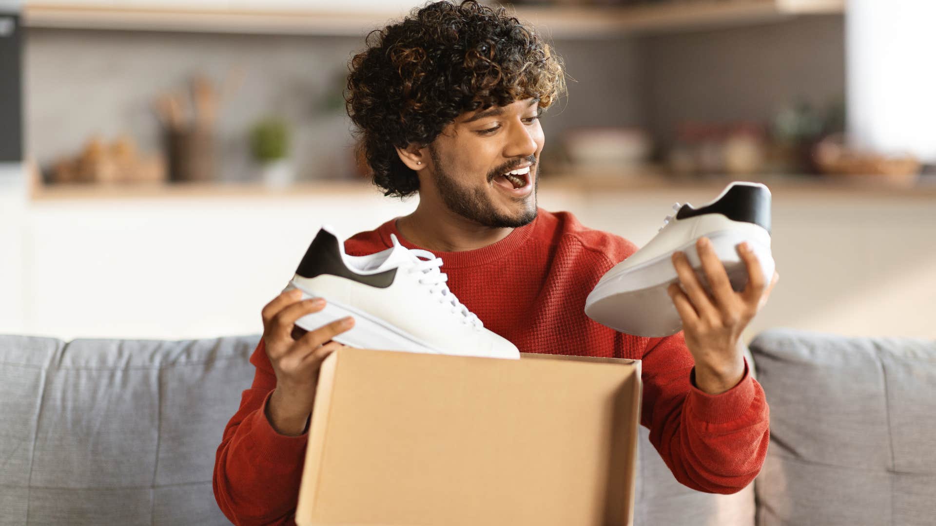 man holding up new shoes justifying his purchase by saying I'm going to get a raise soon don't worry