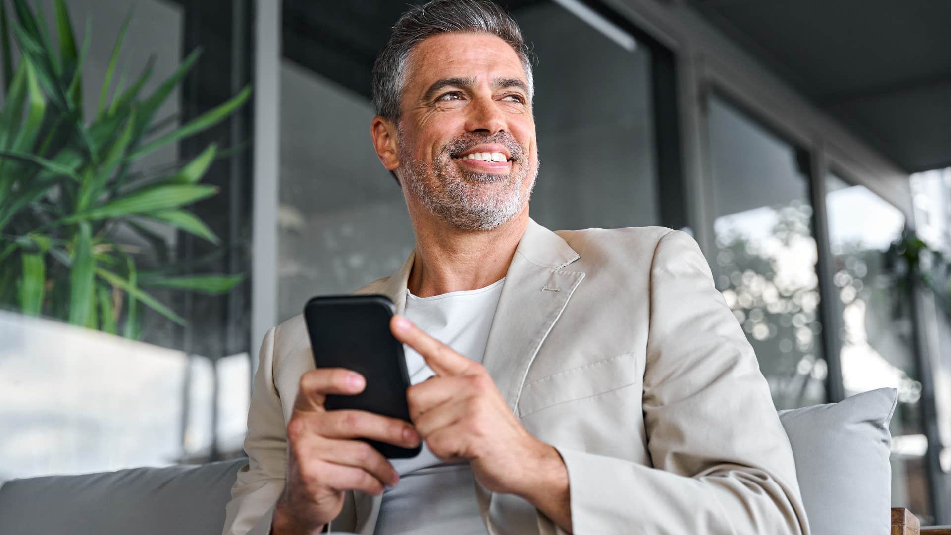 secretly financially stressed man smiling saying he's investing in a lifestyle at work