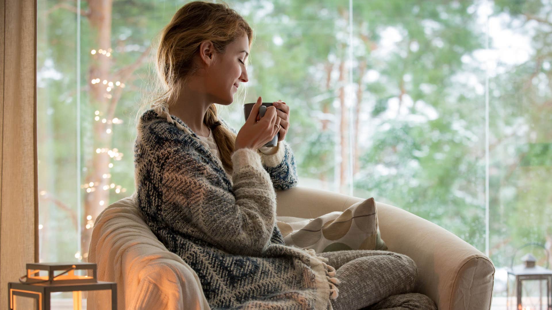 woman sitting in her living room without custom curtains