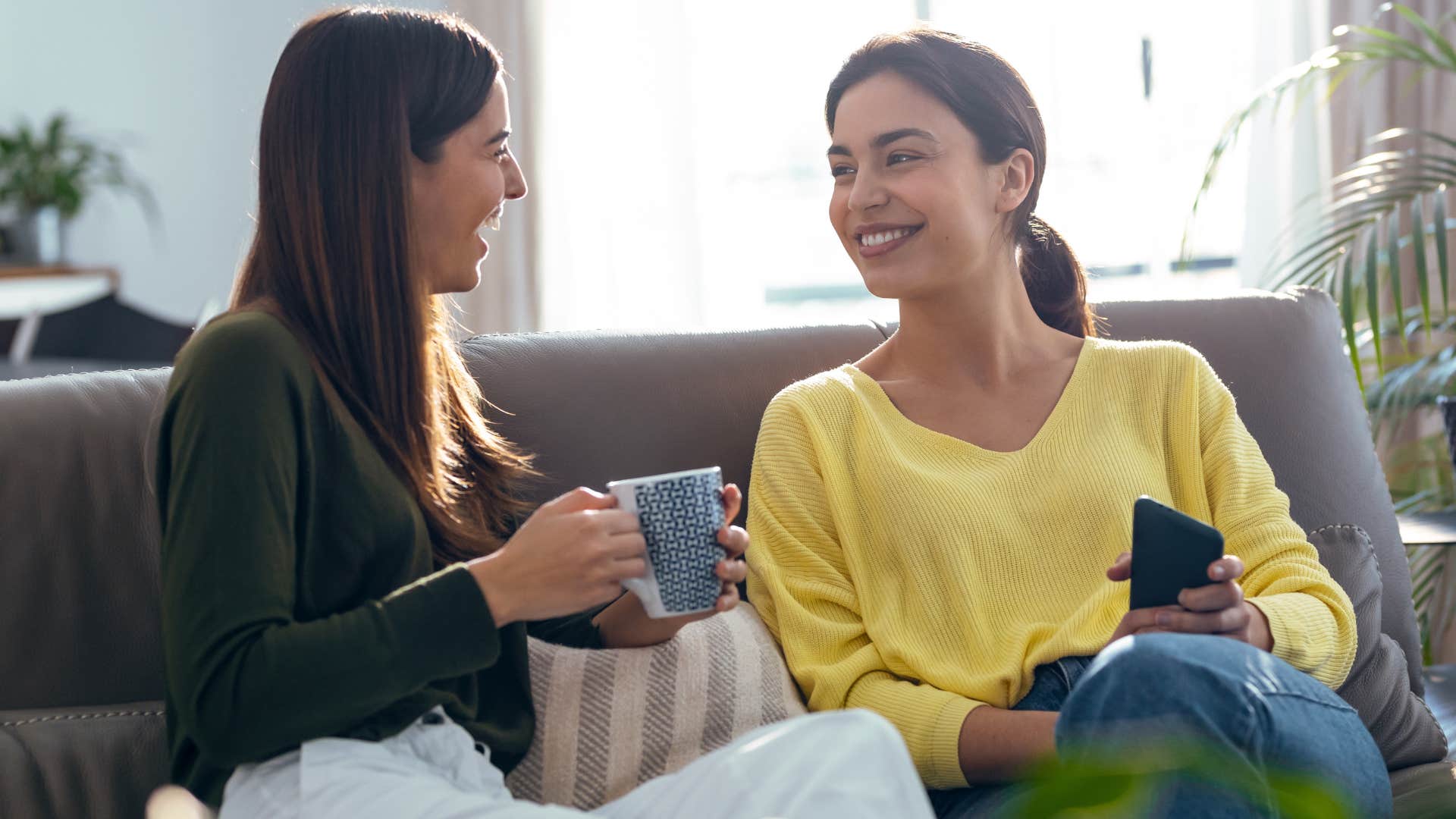 two friends smiling sitting in non-formal living room