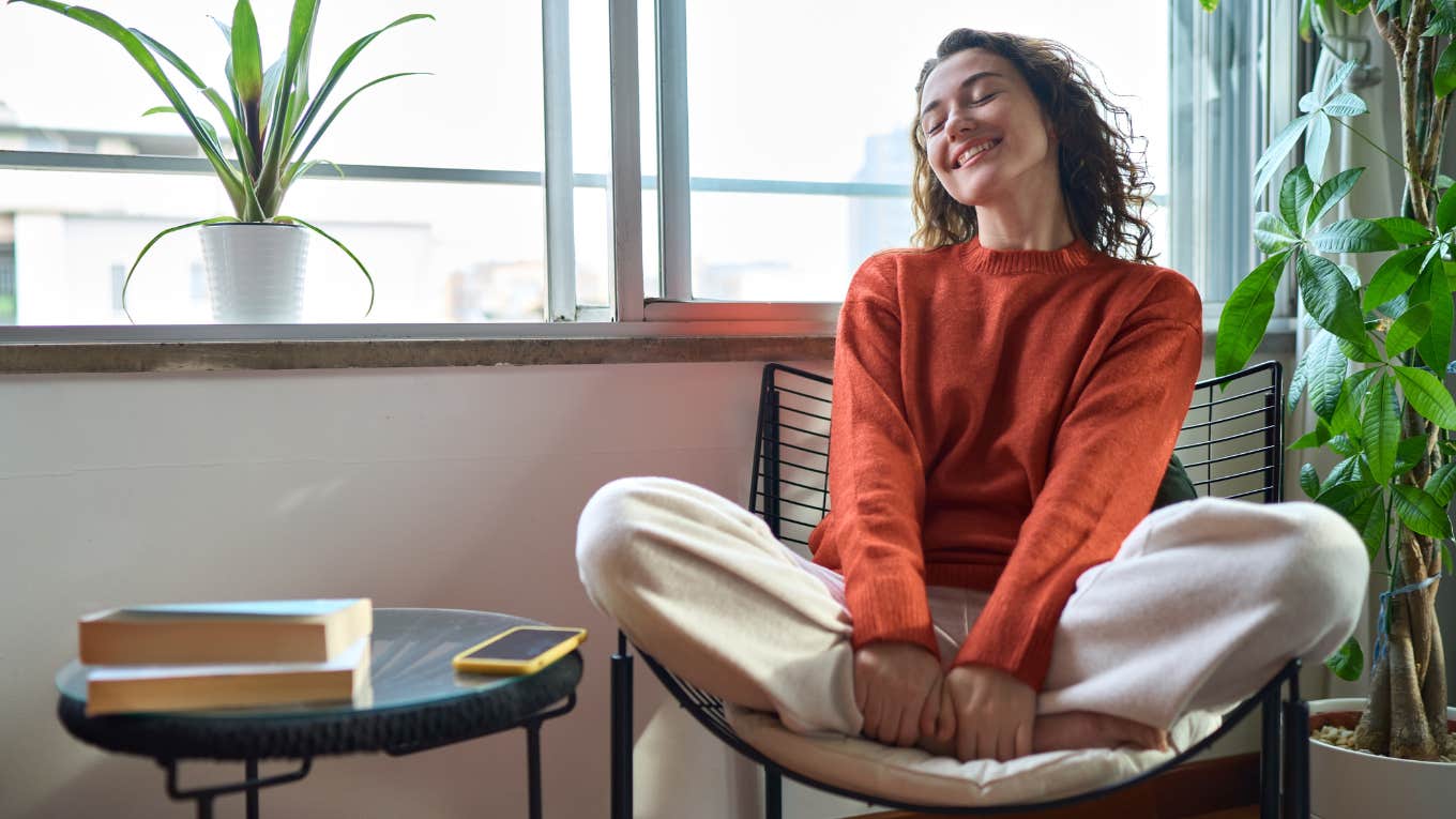 smiling woman sitting home alone