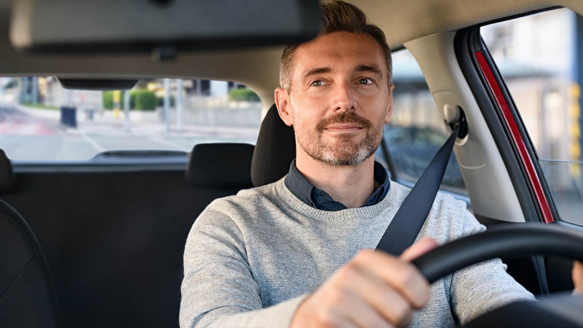 man driving brand new car