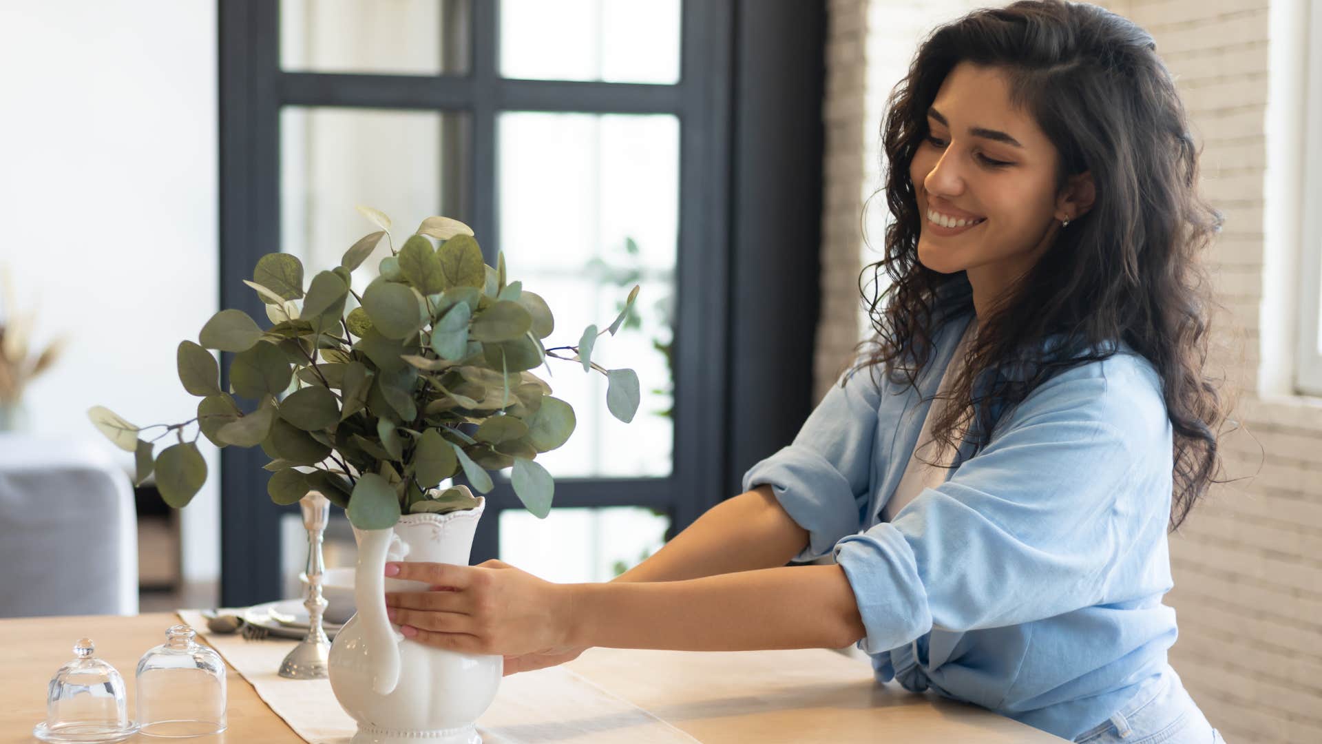 woman putting trendy home decor on her table