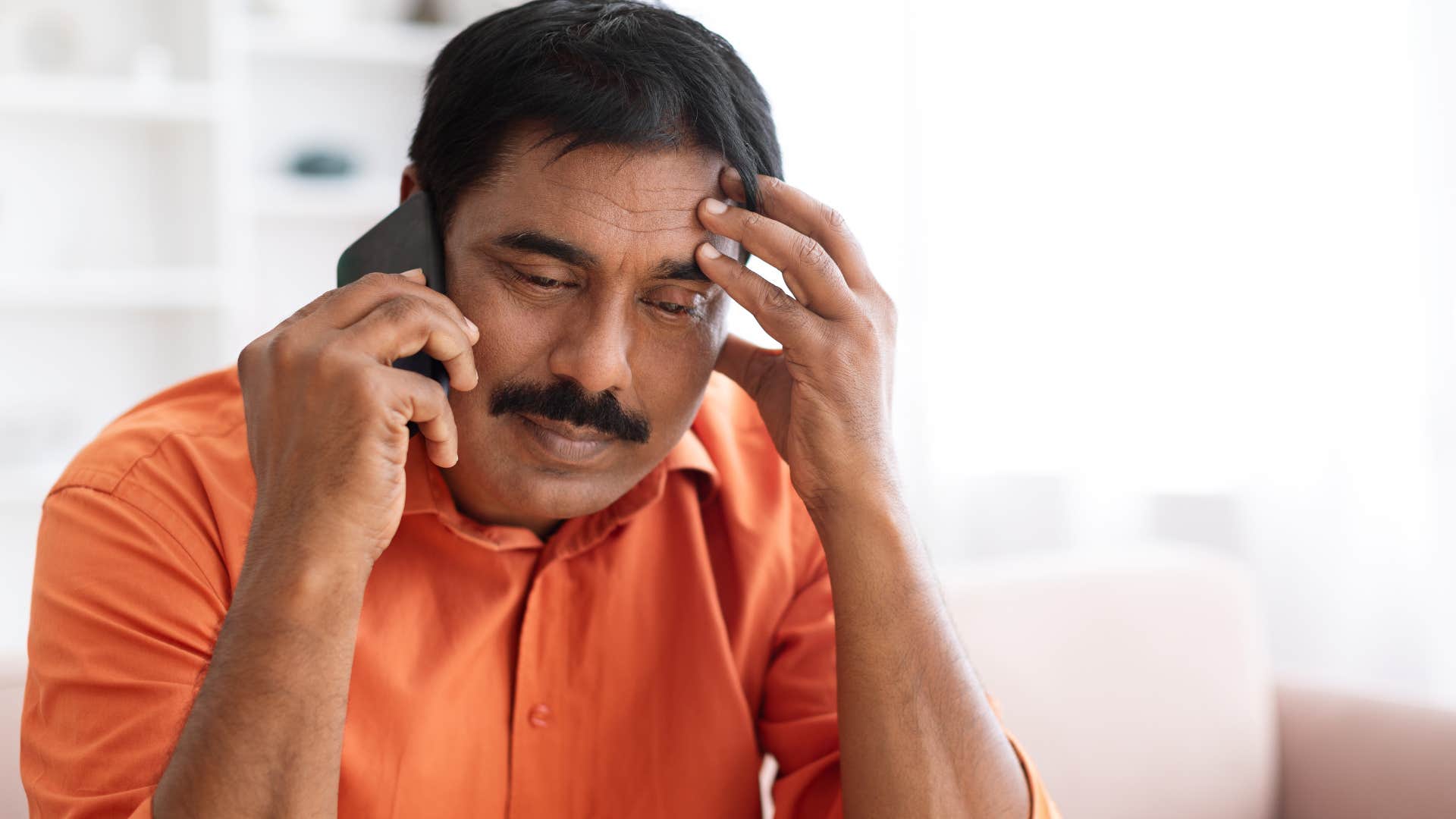 exhausted man talking about dishonesty on the phone