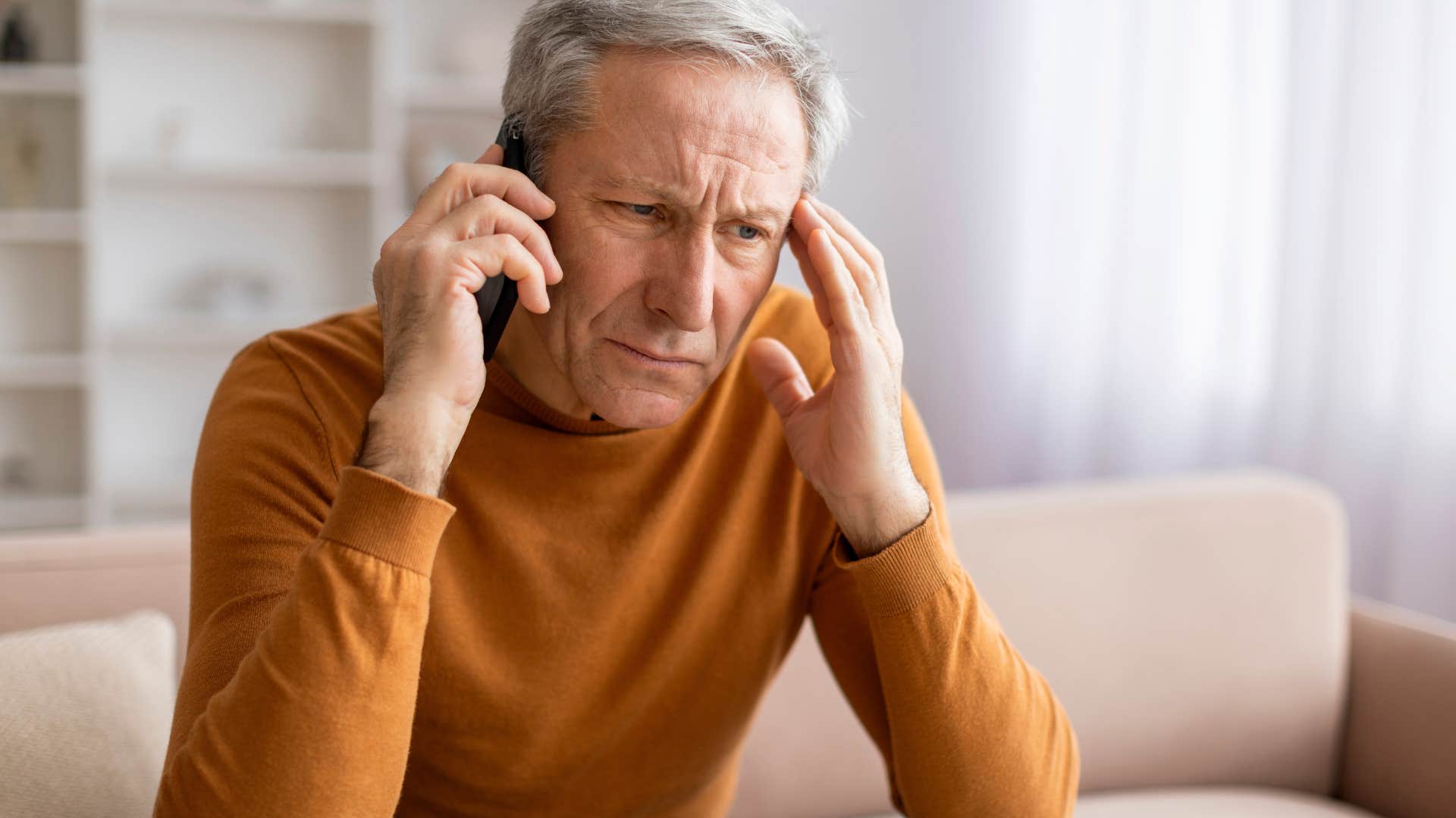 overwhelmed man on the phone with person who talks too much