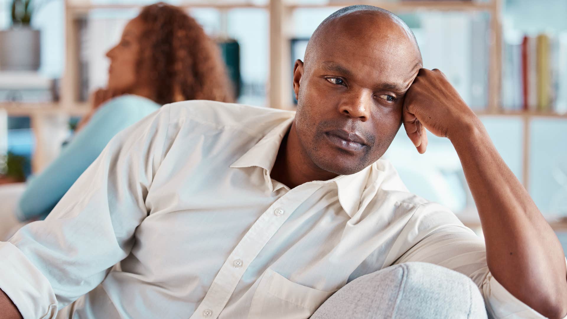 man avoiding vulnerability turned away from his partner