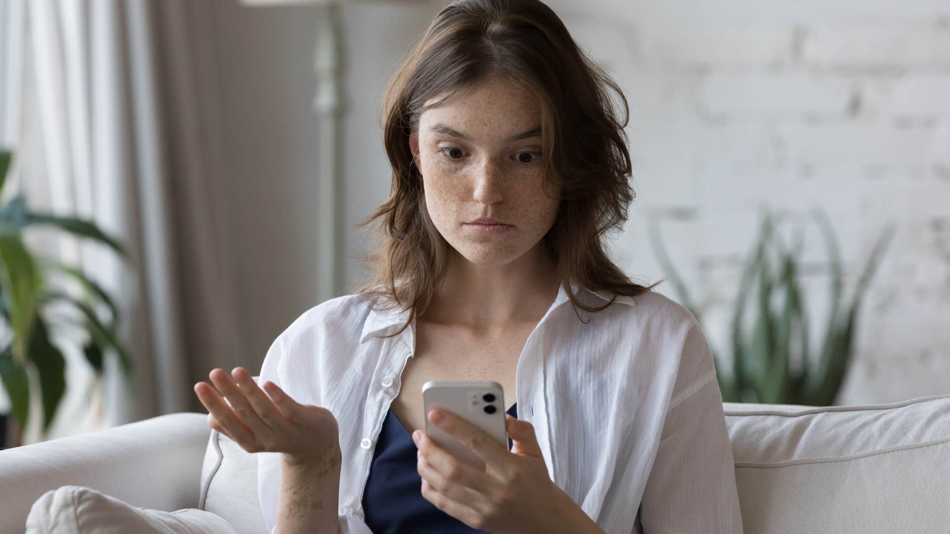 annoyed woman looking at messages from flaky people canceling