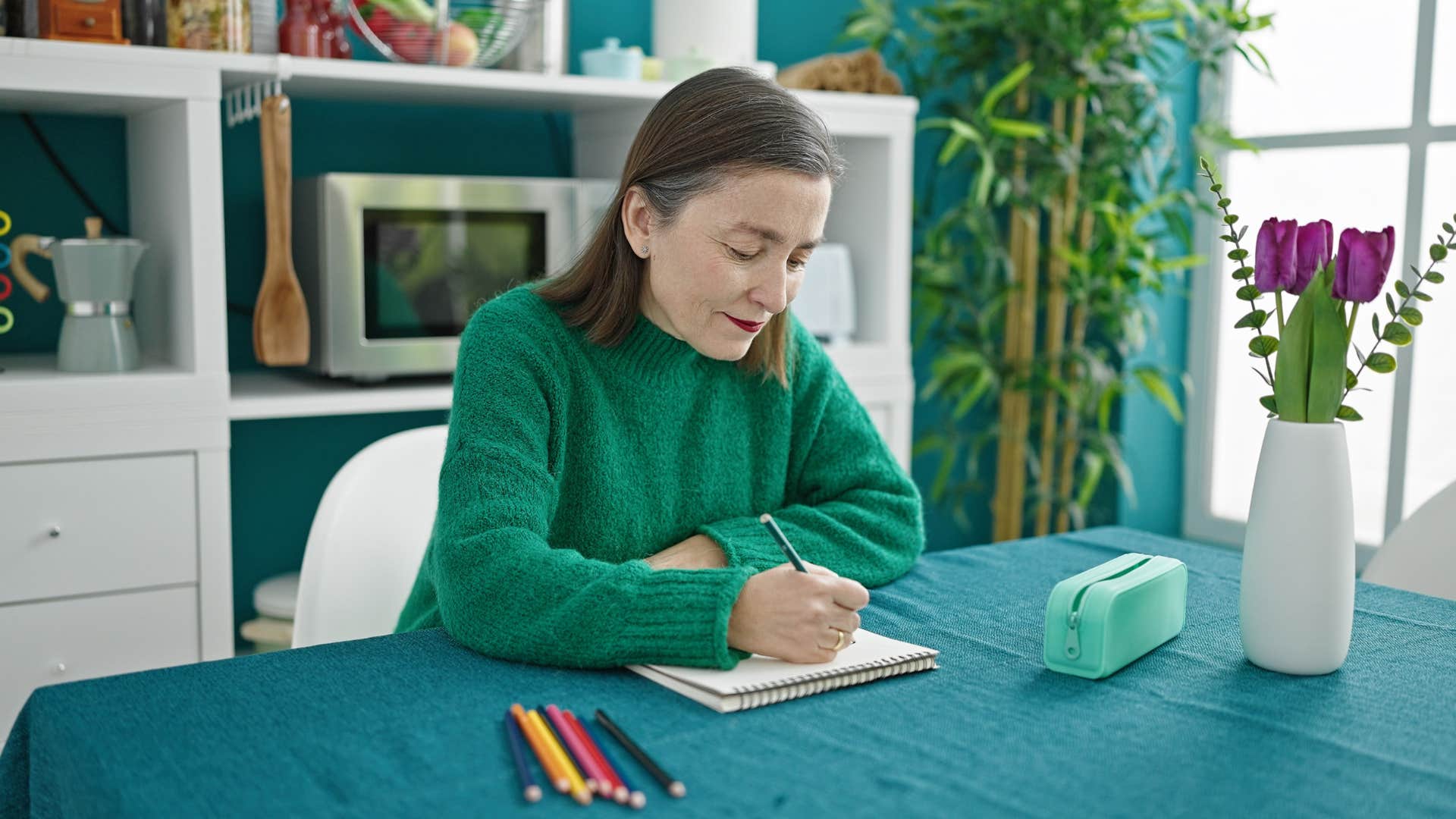 woman sitting in her kitchen surrounded by decor thats not cohesive