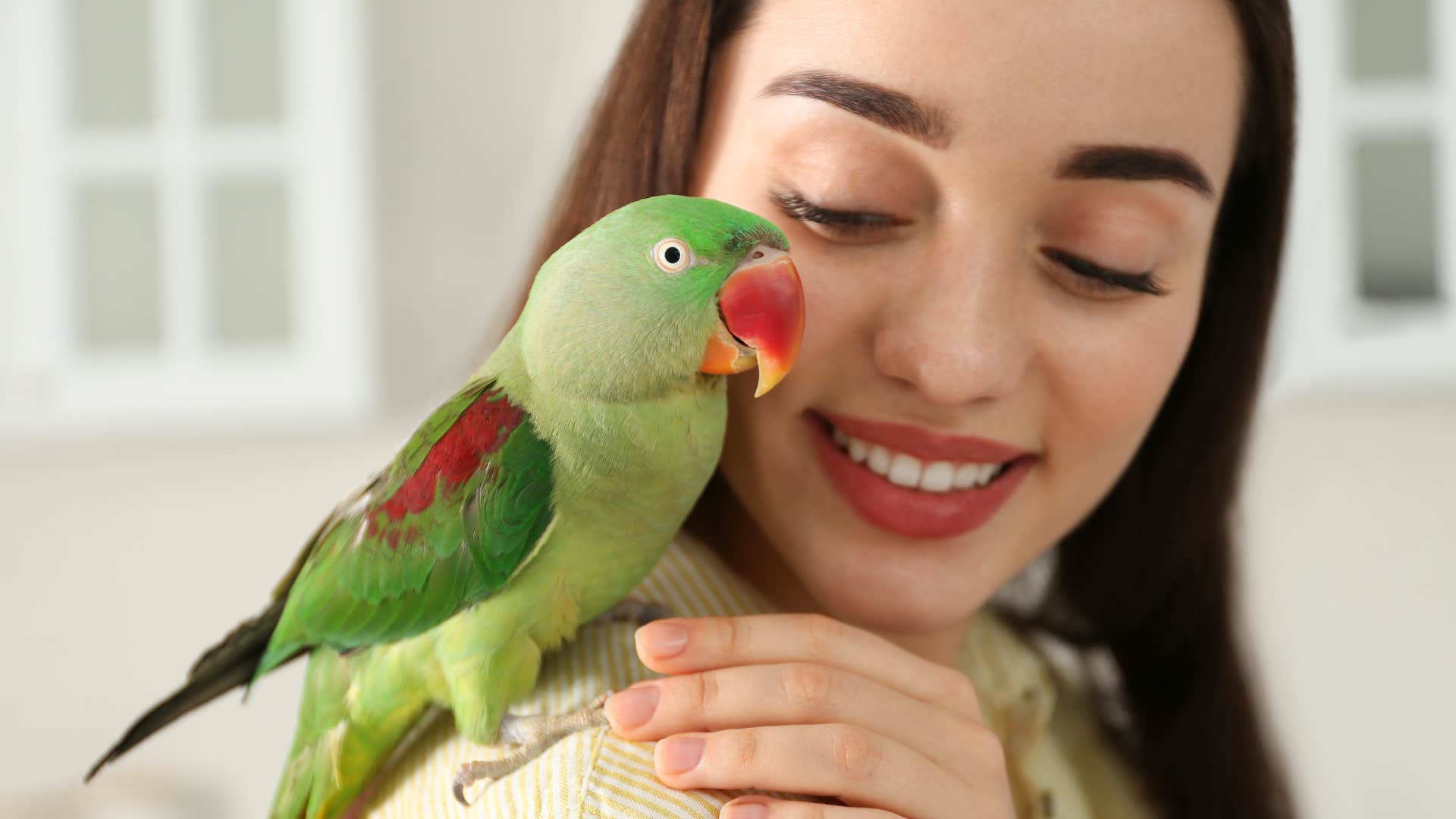 woman caring for exotic animals holding a bird