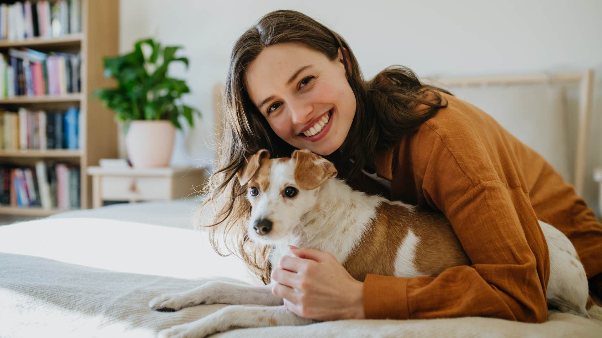 woman making a room for her pets smiling with her dog