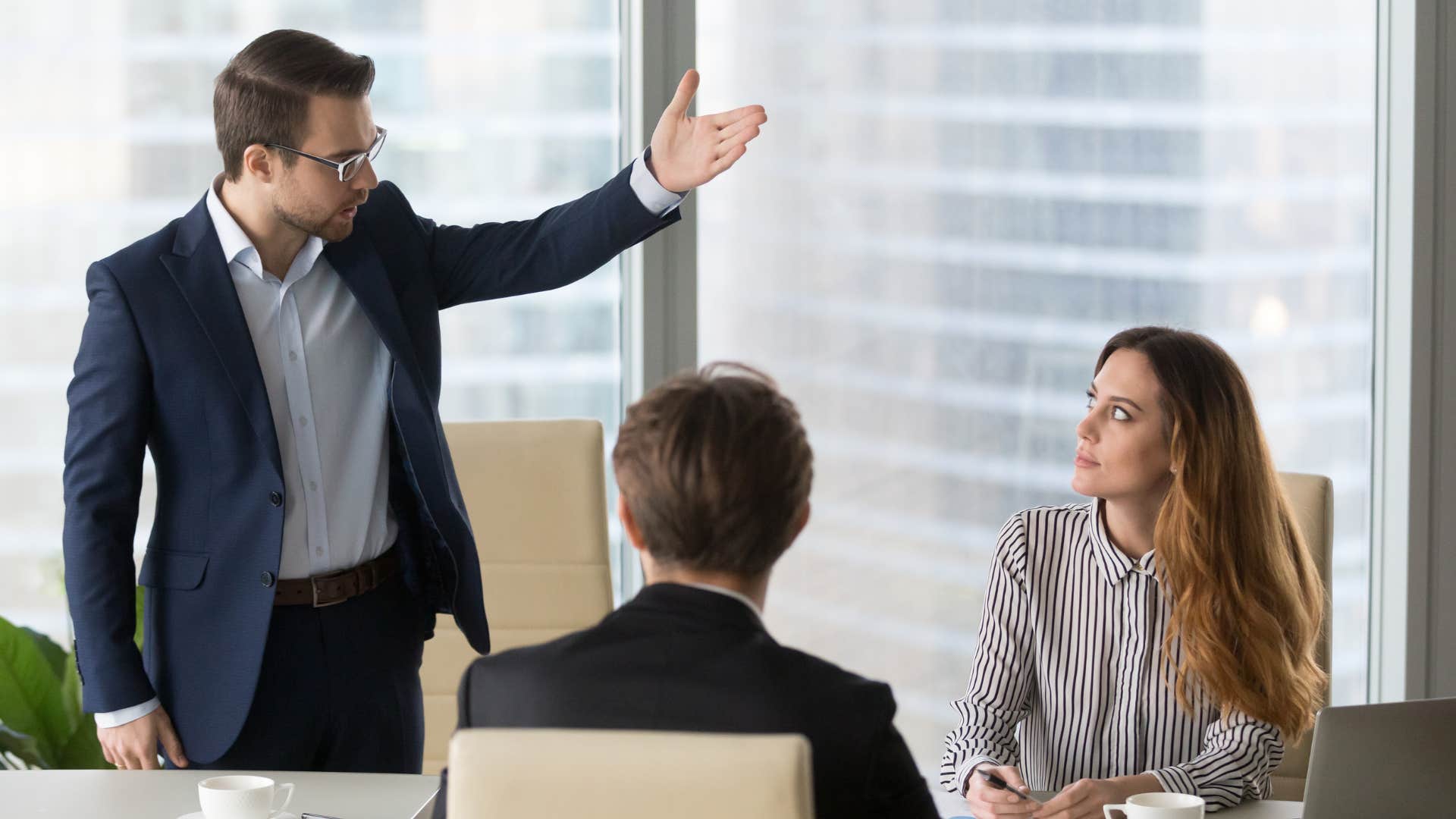 a man notices his boss shifting the blame to his female colleague