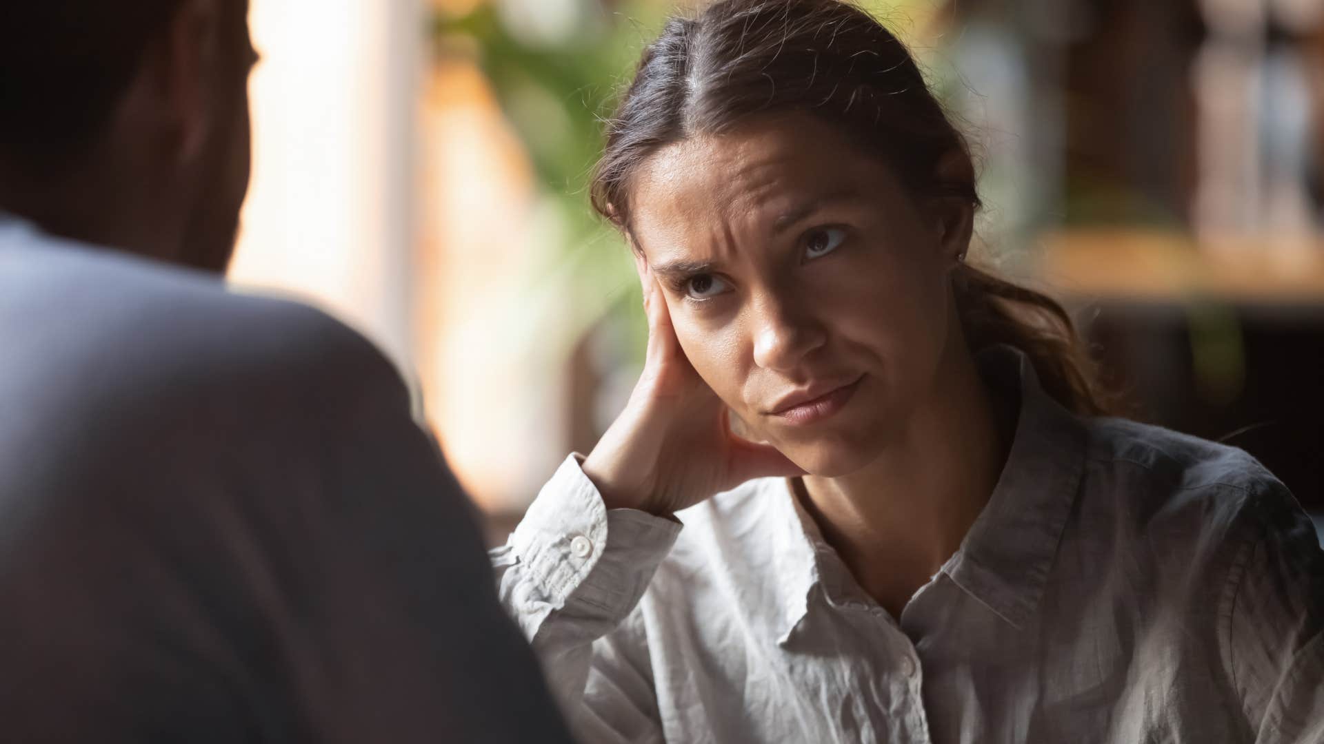 upset woman listening to man interrupt her while she speaks