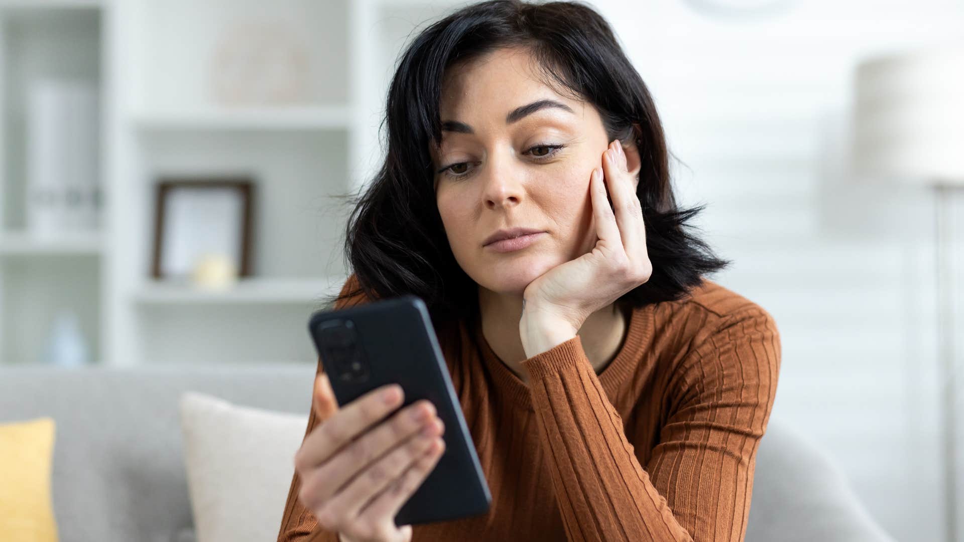 woman looking at her phone during a conversation