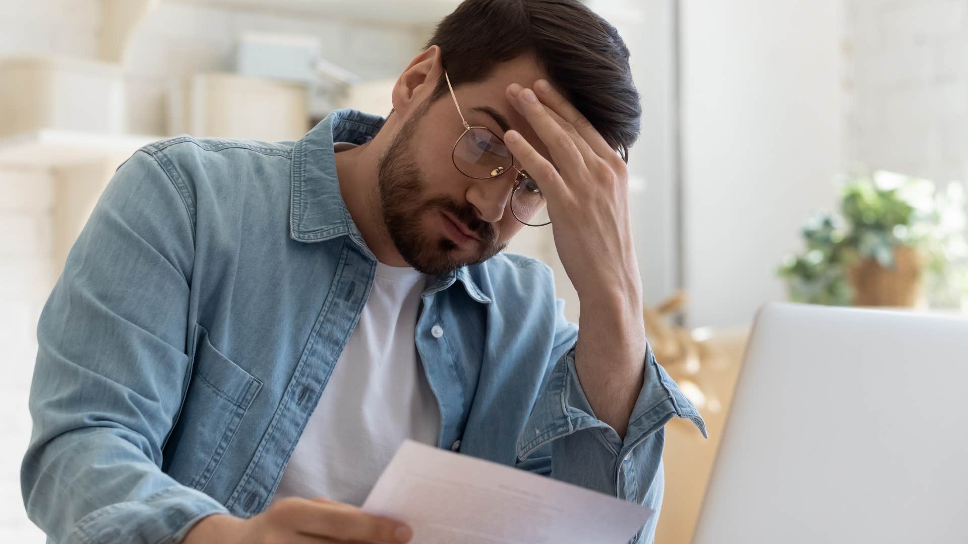 Man looking at hidden fees and rising prices on a bill.