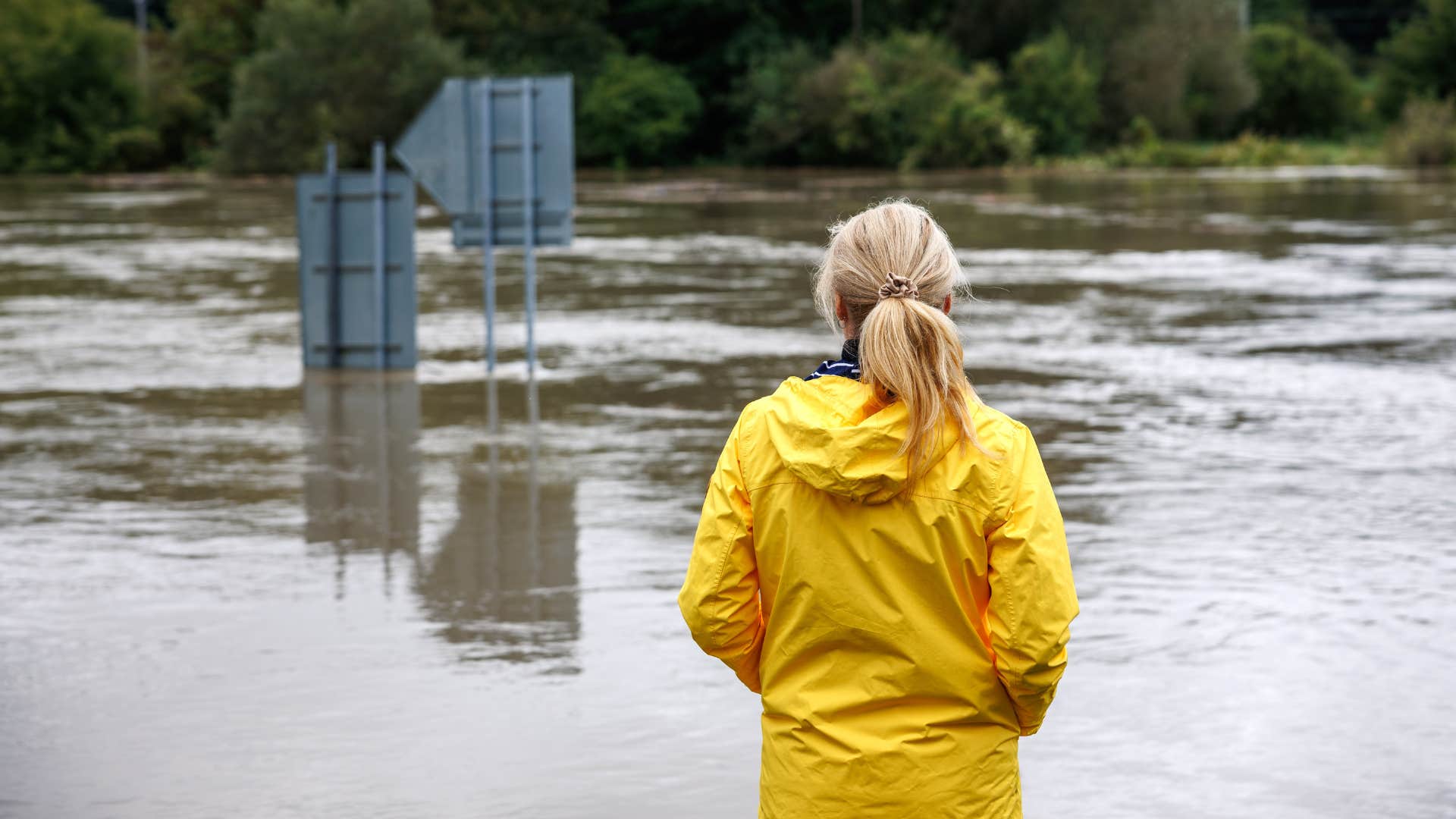 a gen z woman stares out as her home town is completely flooded in the span of a couple of hours