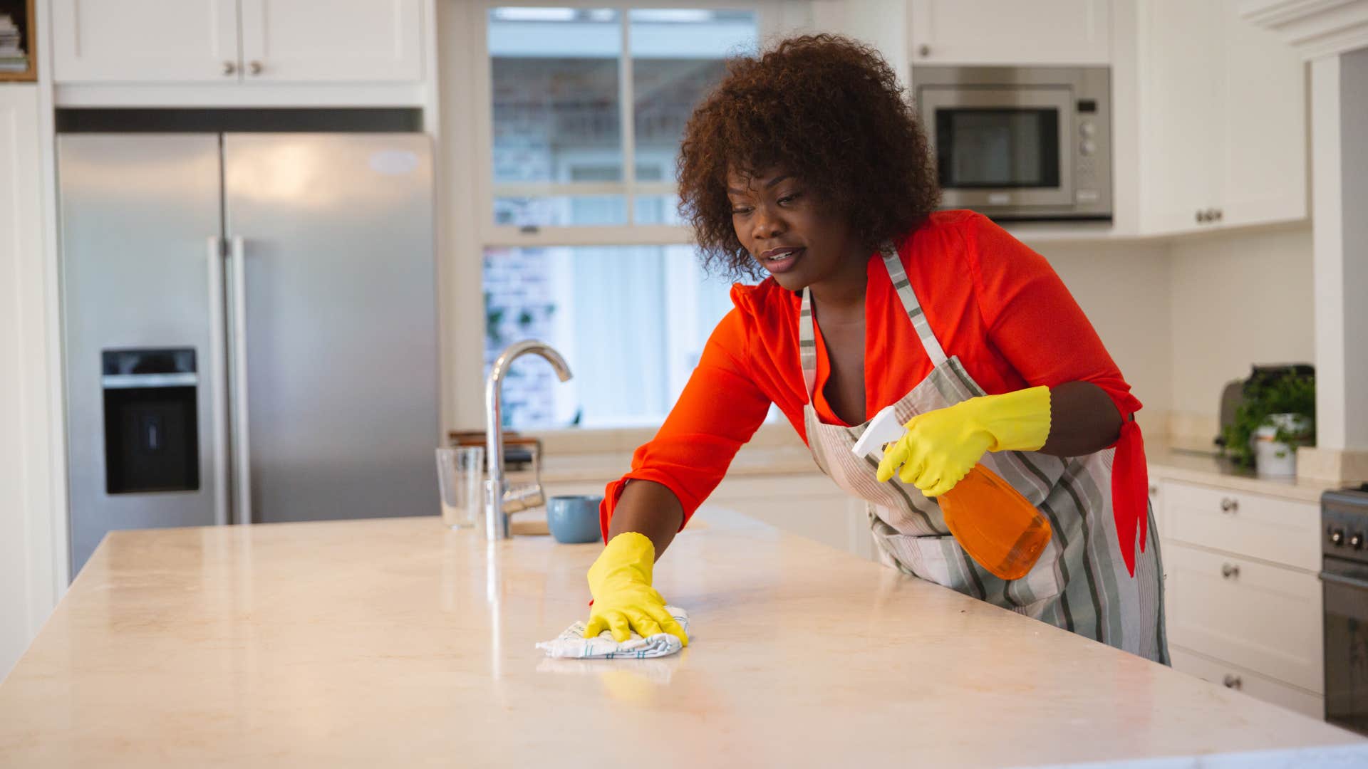 woman cleaning counter in her kitchen