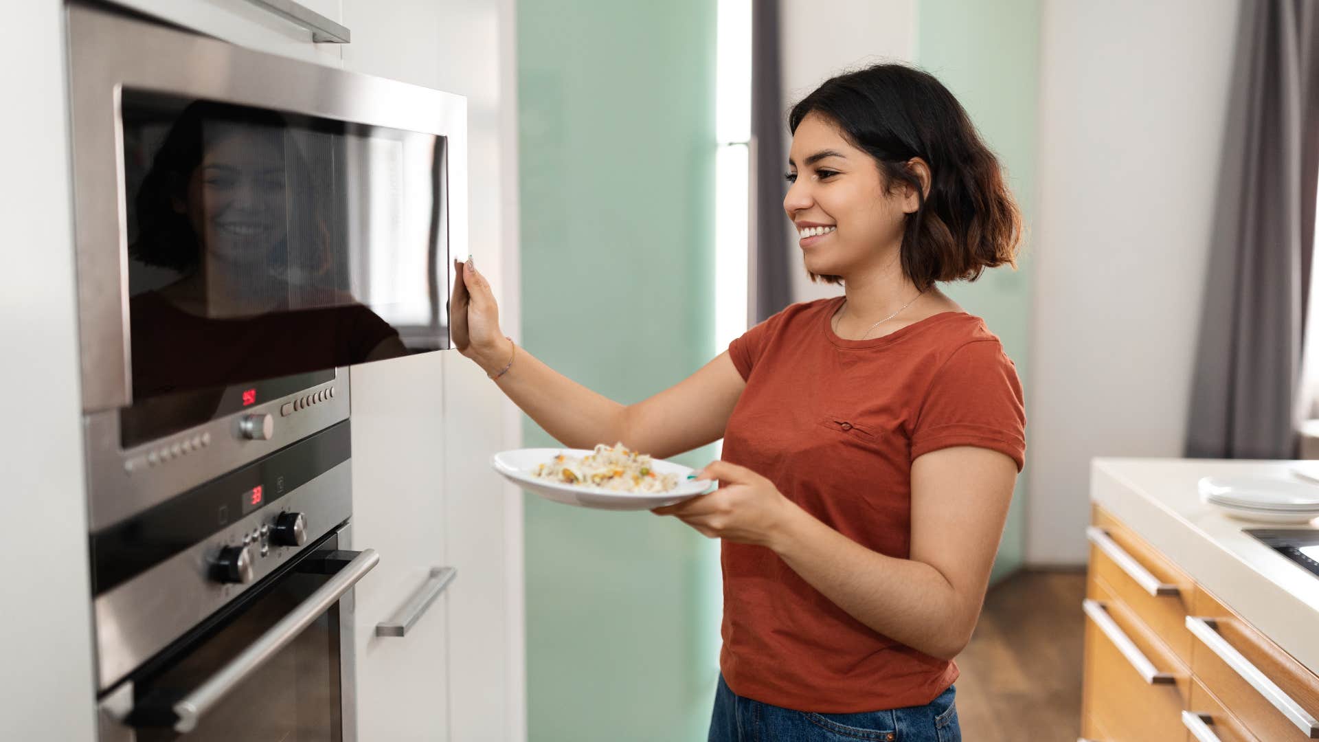woman heating up food in microwave