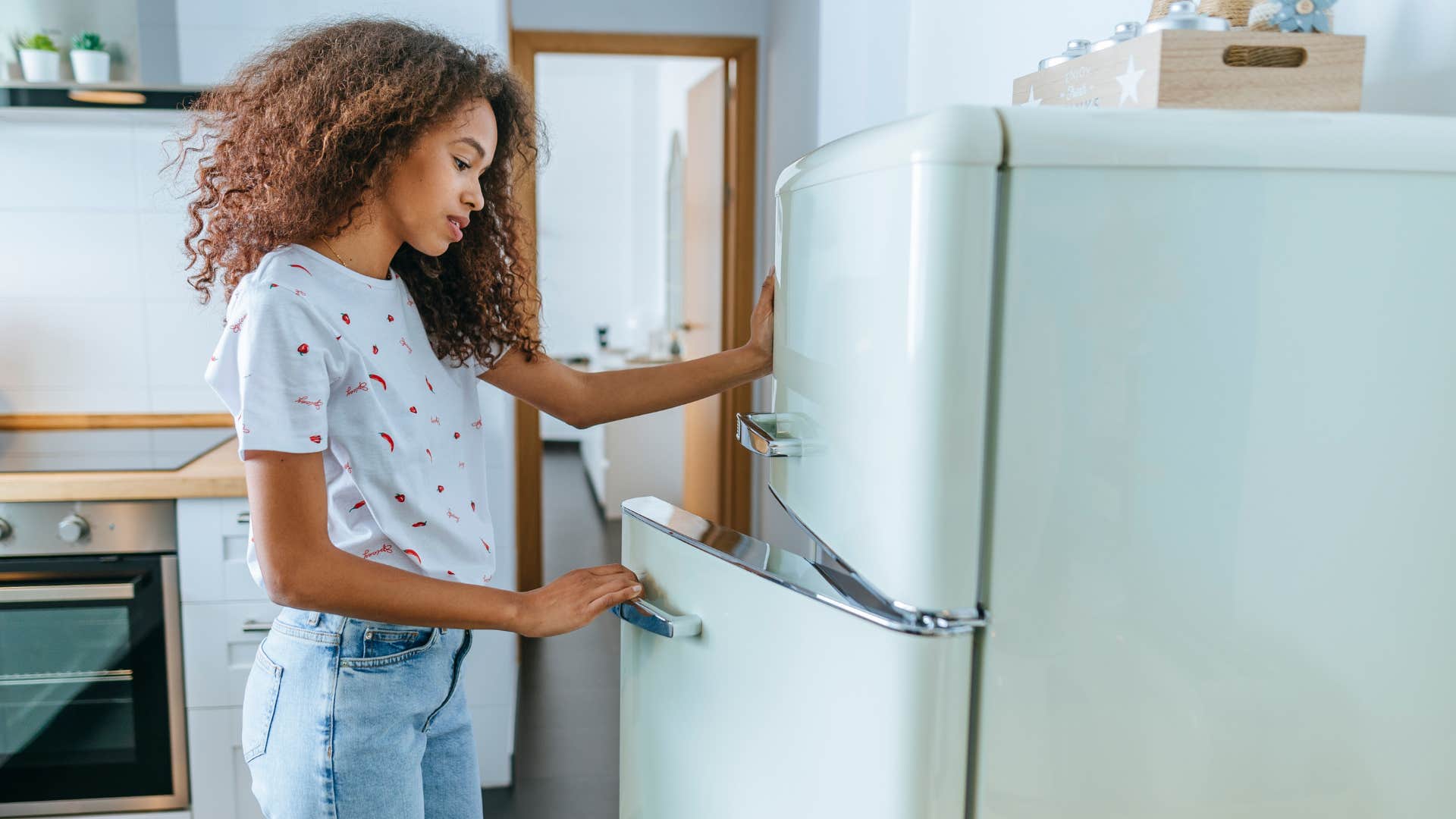 woman opening fridge in kitchen
