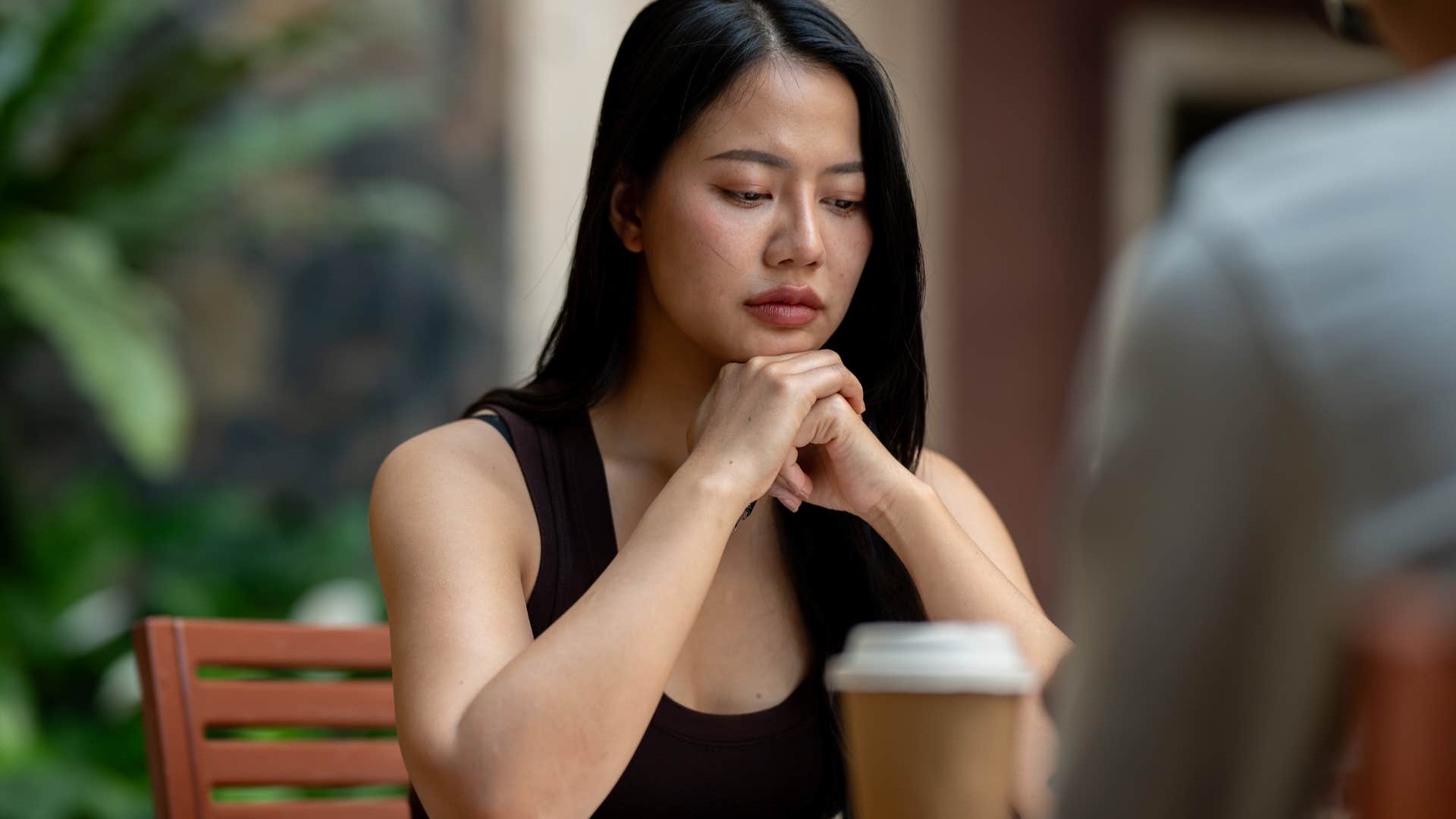 disappointed woman sitting at table saying no