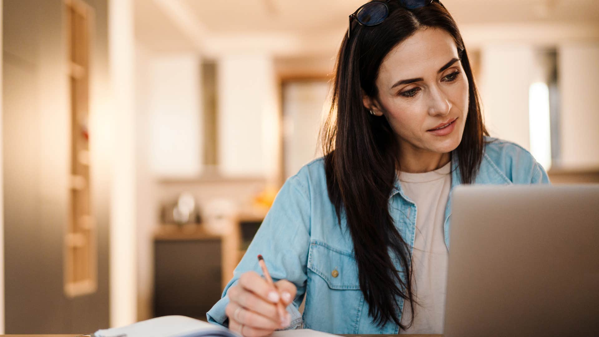 woman writing in her paper calendar at her desk