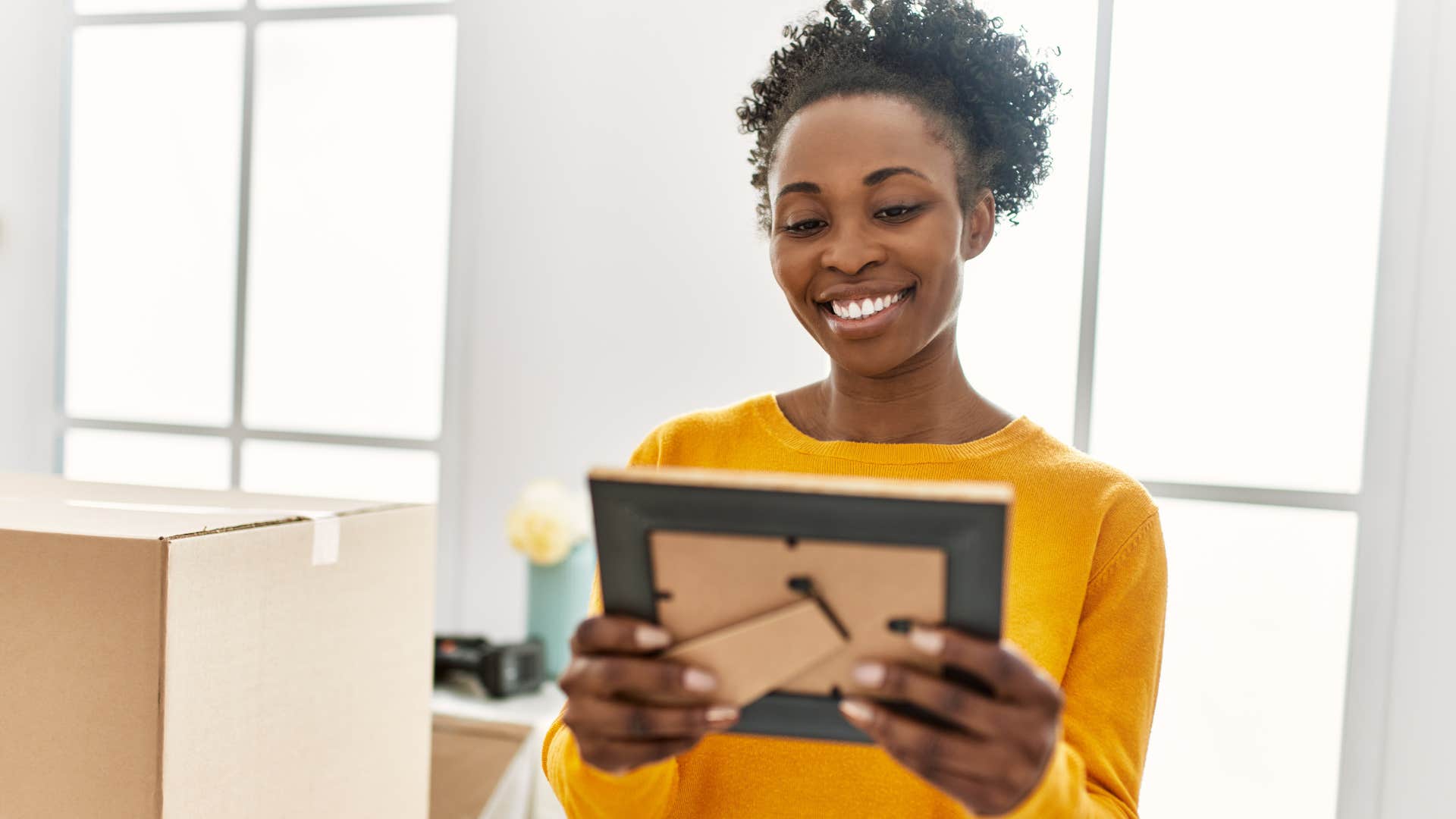 woman smiling and looking at personal photos to hang at home