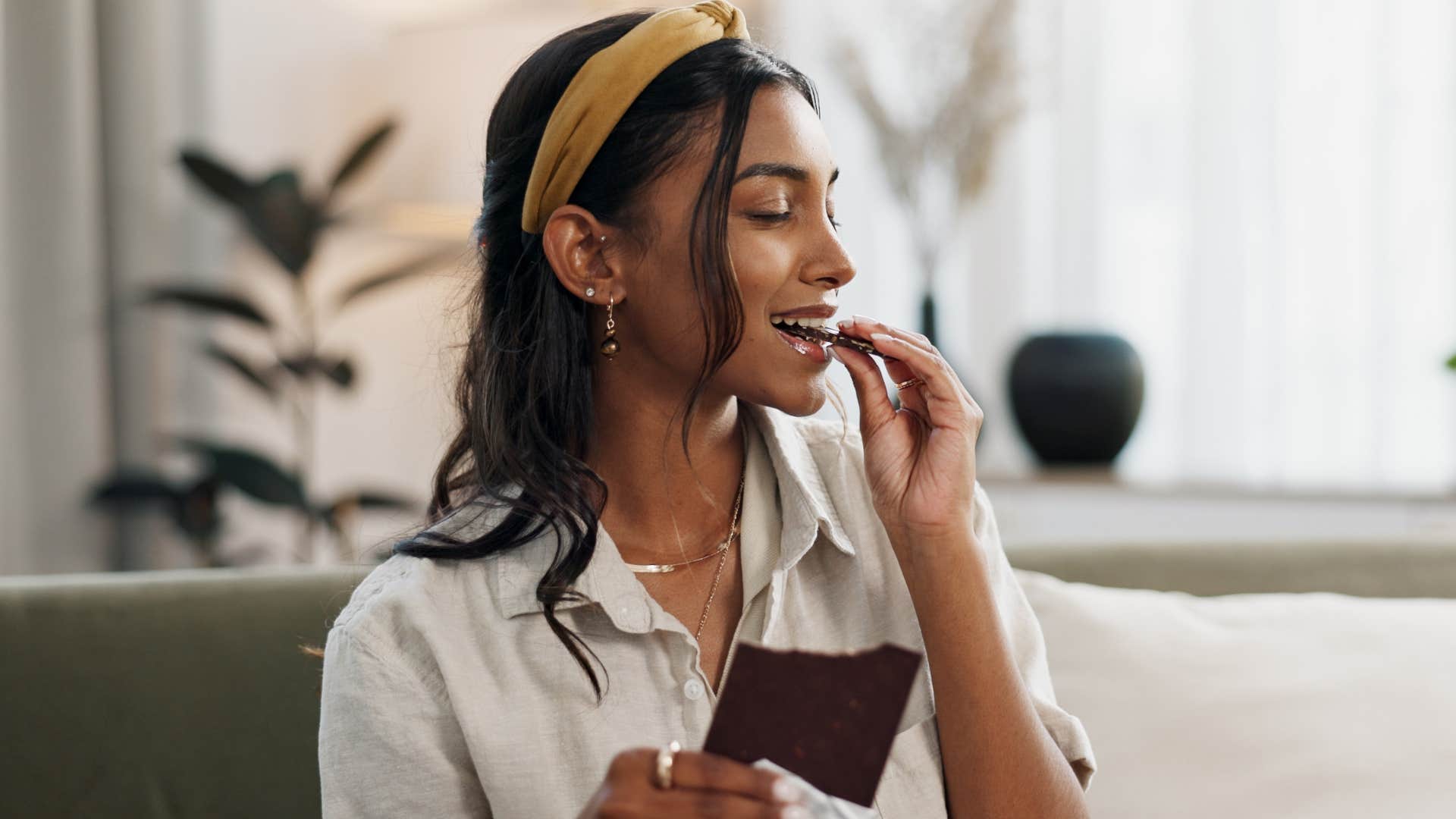 woman eating chocolate at home from her snack stash