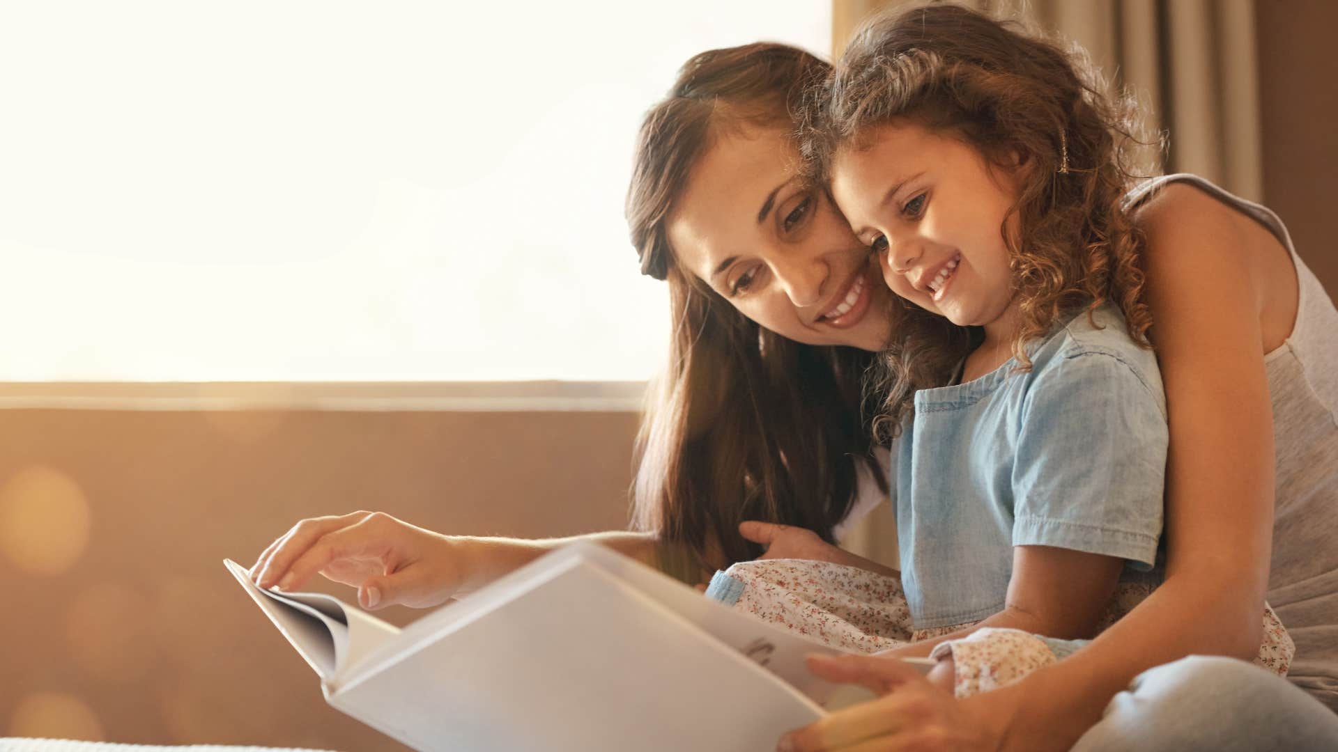 a sentimental mother reads her young daughter her favorite book as a child