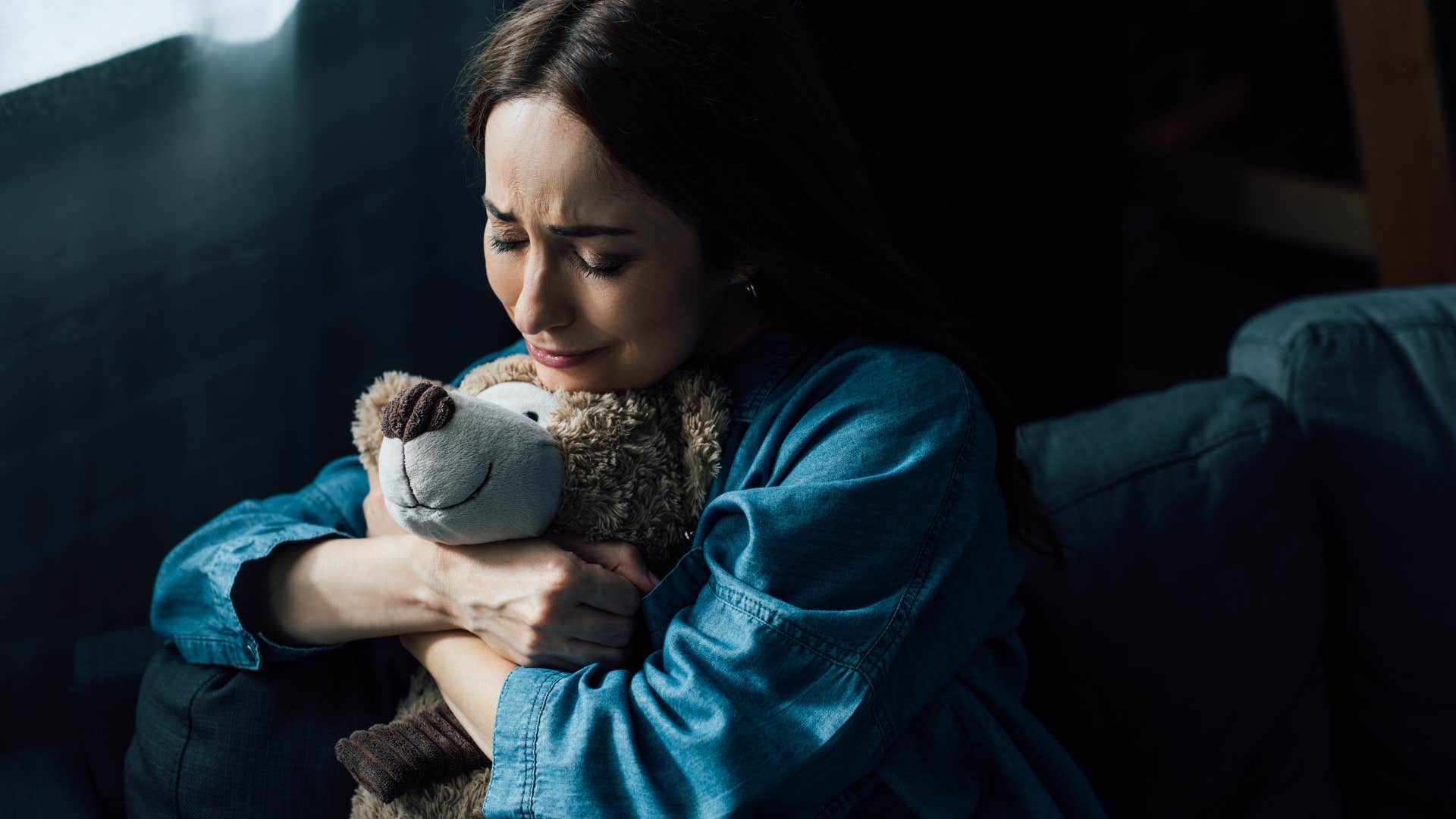 an adult woman finds her stuffed teddy bear from childhood