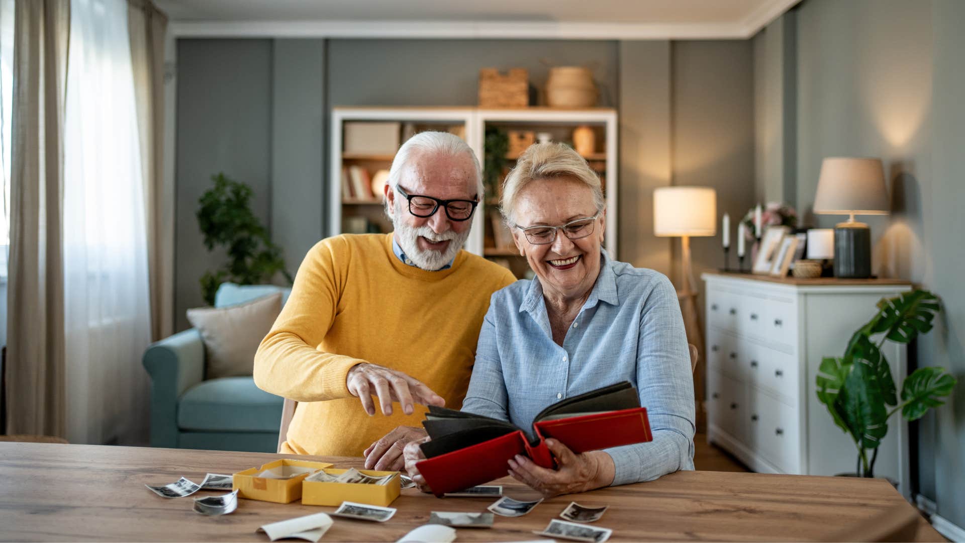 a sentimental elderly couple looks over their family photos