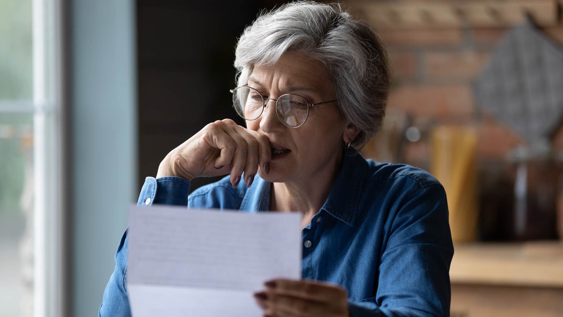 an older woman reads her old letters from her deceased friends