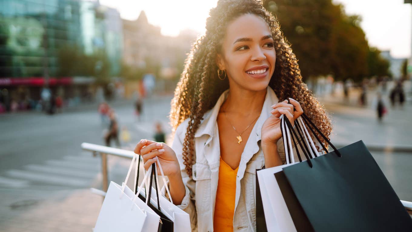 Unfortunate Things Working Class People Waste Money On While Thinking They're Leveling Up working class woman overspending on shopping spree