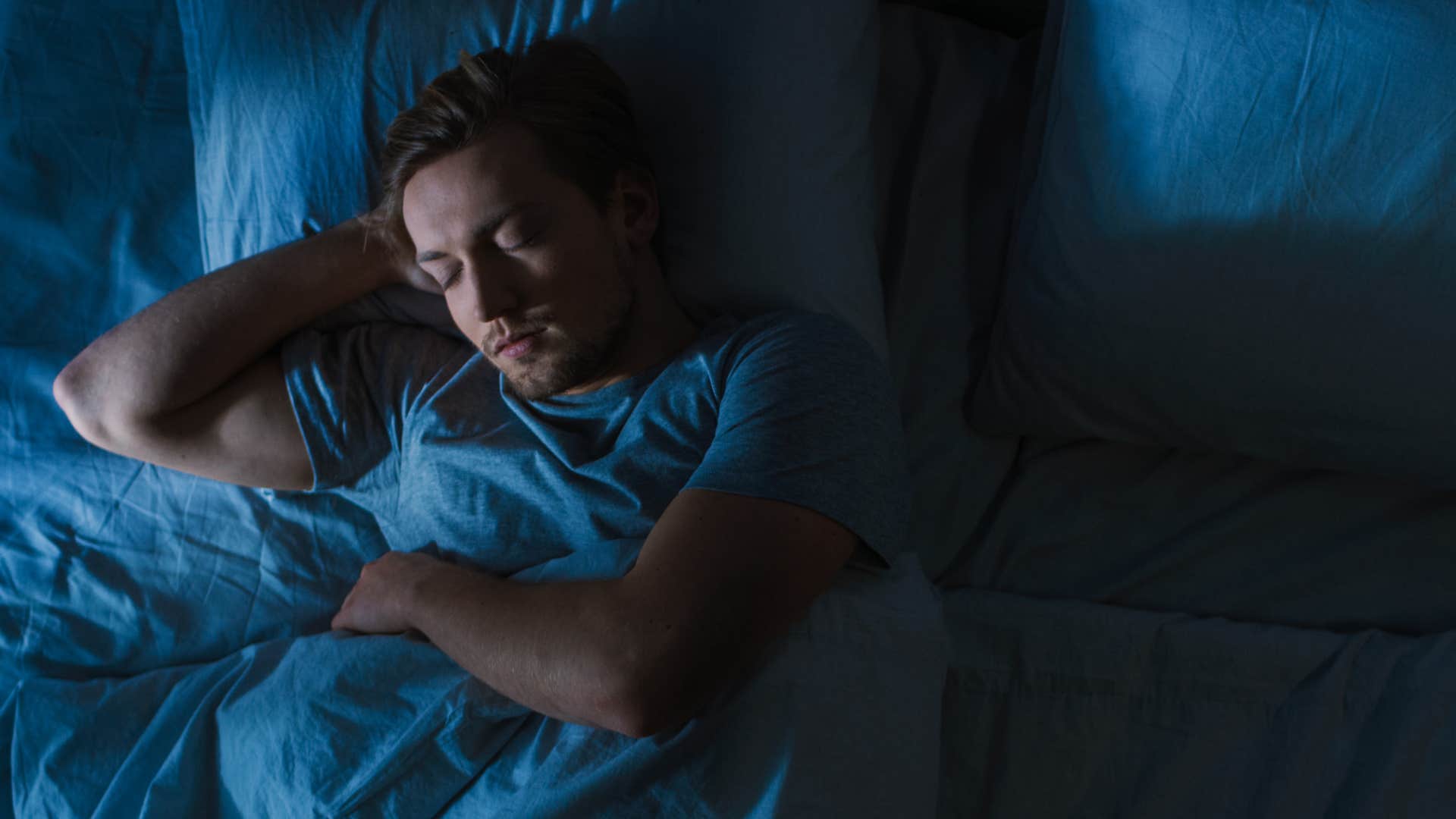 Man sleeping in a room with blackout curtains.