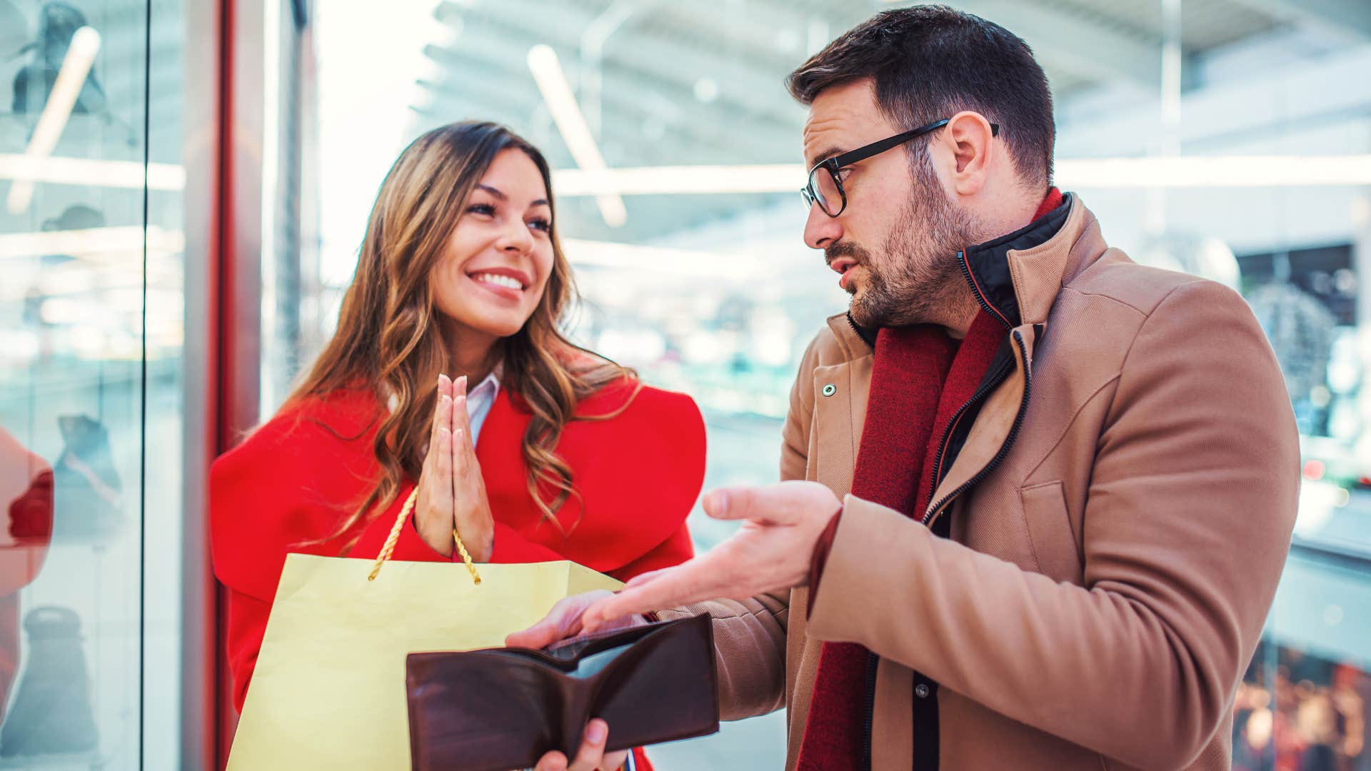 Woman saying "you only live once" to her partner holding his wallet.