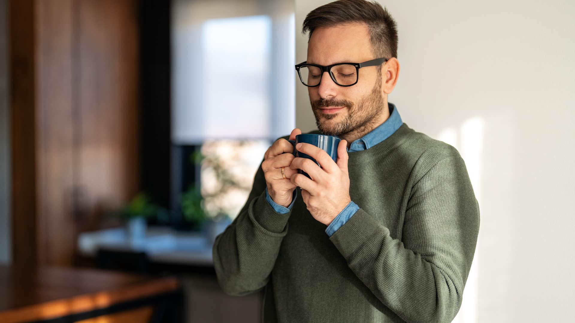 man smiling and drinking coffee from single-use pods