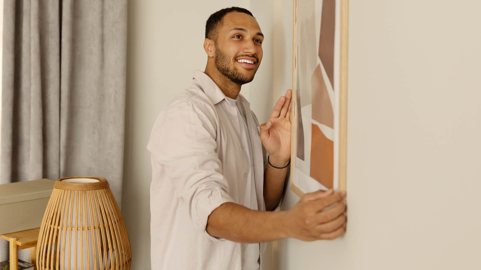 man hanging up designer home decor