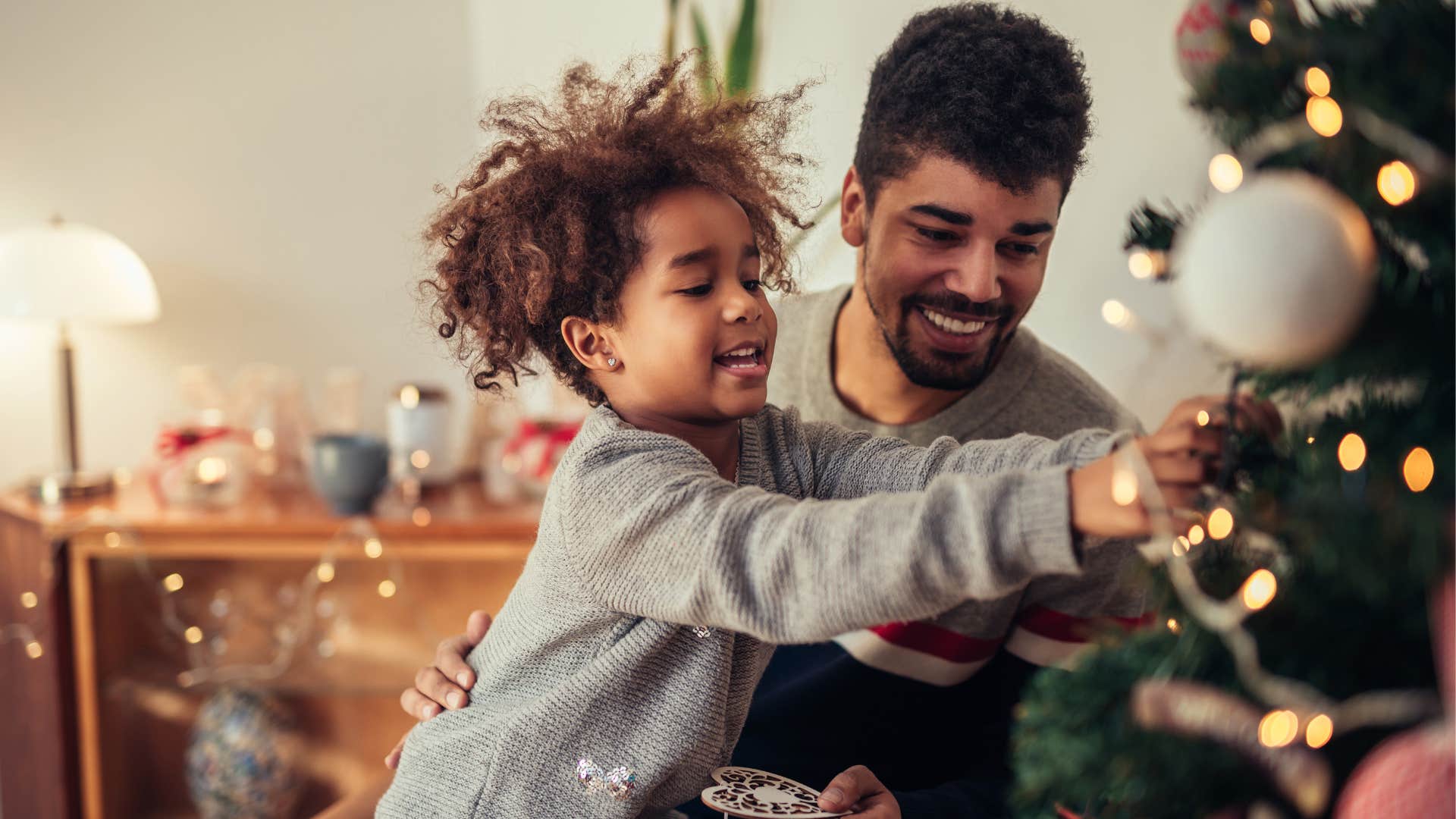 man putting up excessive holiday decor with his son
