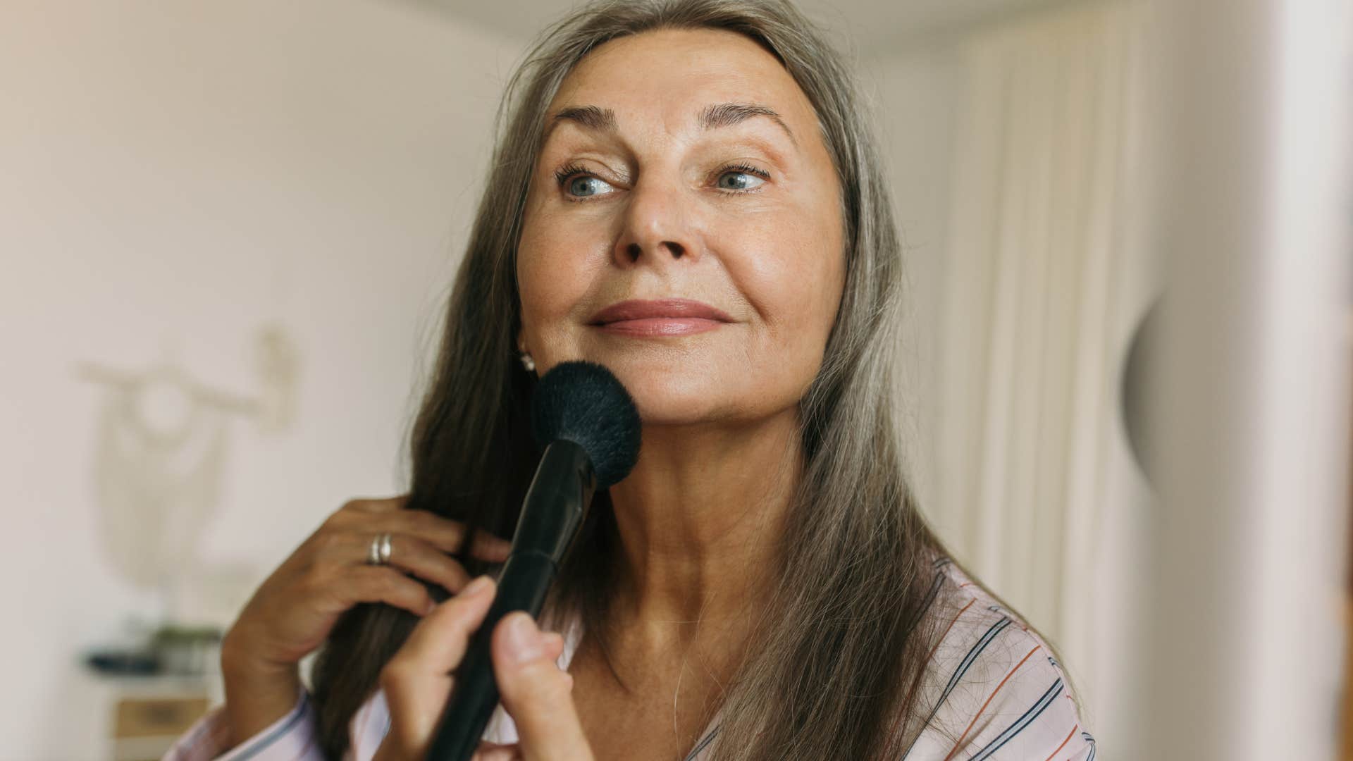 woman doing her makeup with name-brand products