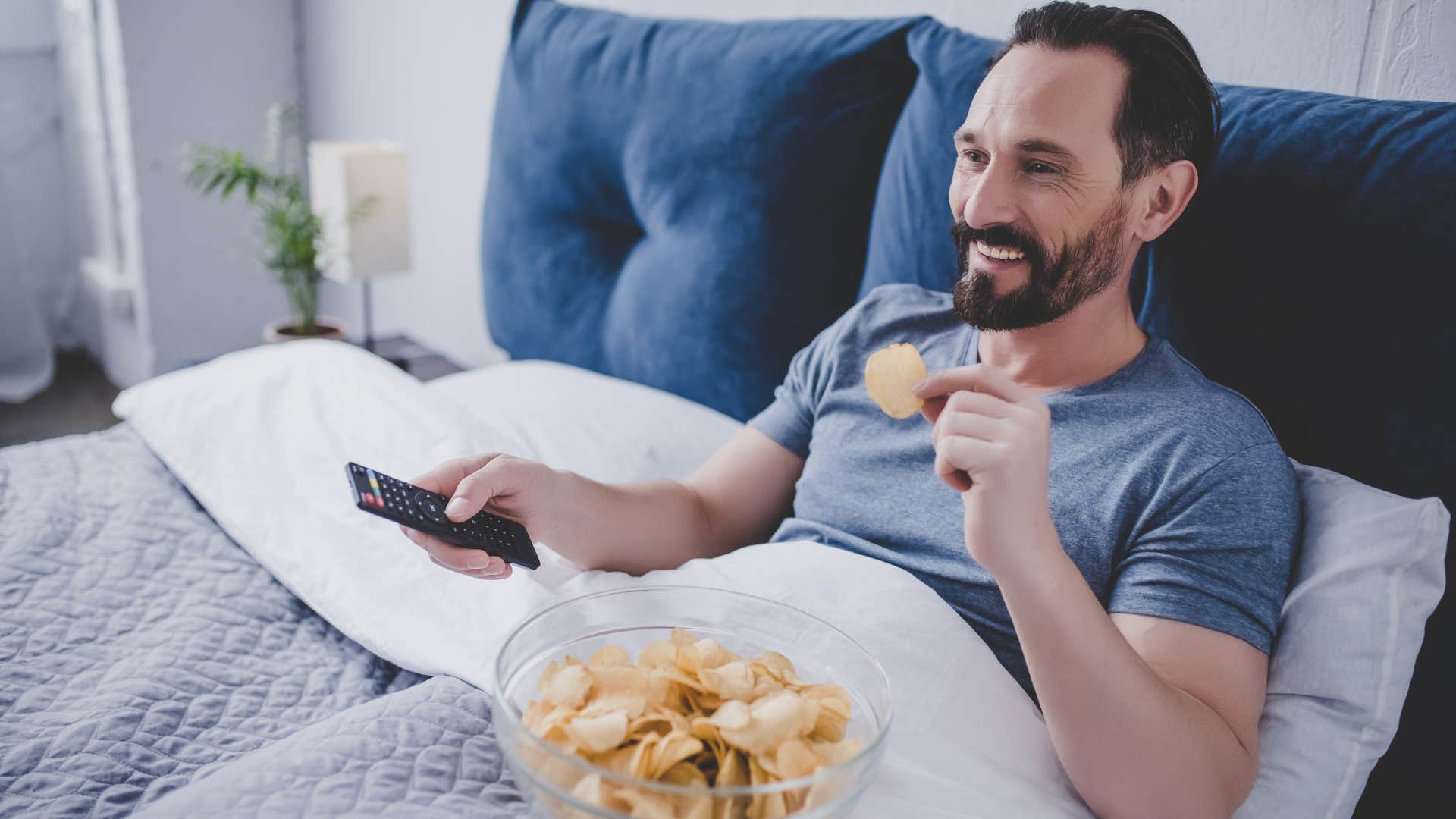 man with TVs in every room watching in his bed