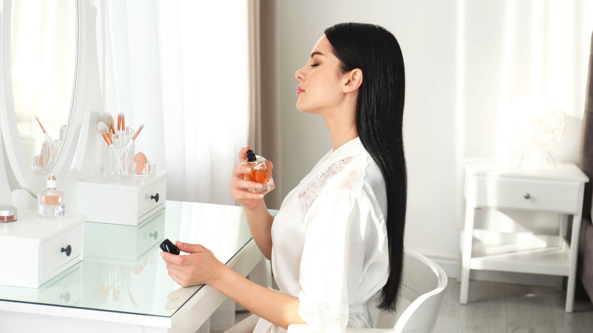 woman spraying herself with perfume