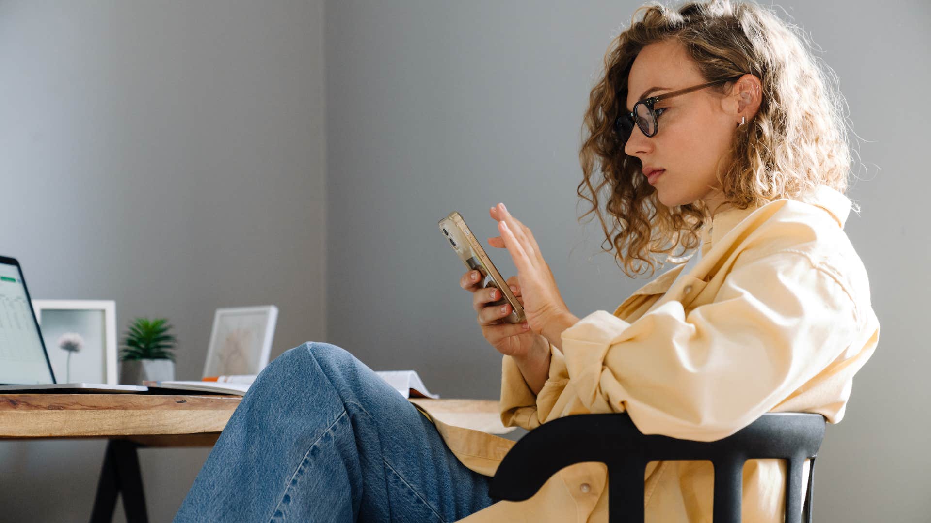 woman looking at her phone at her desk