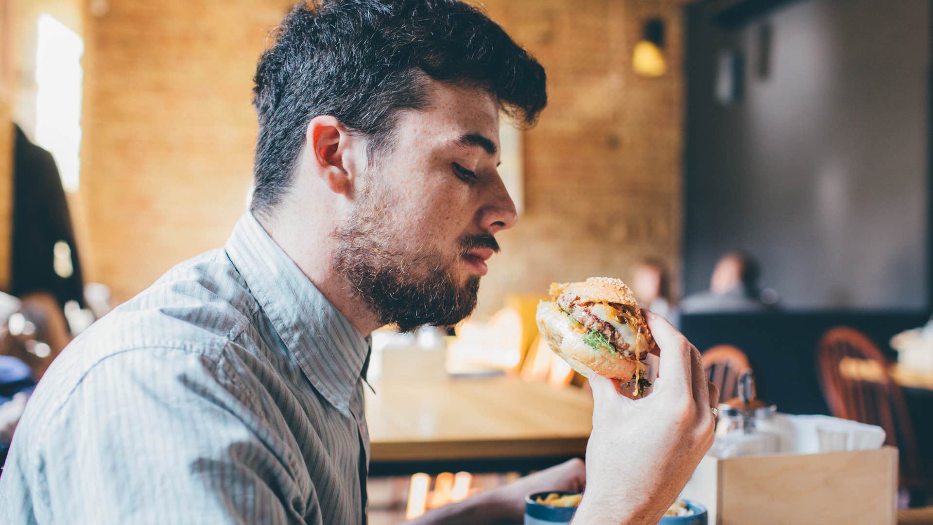 man eating a burger at a fast food restaurant