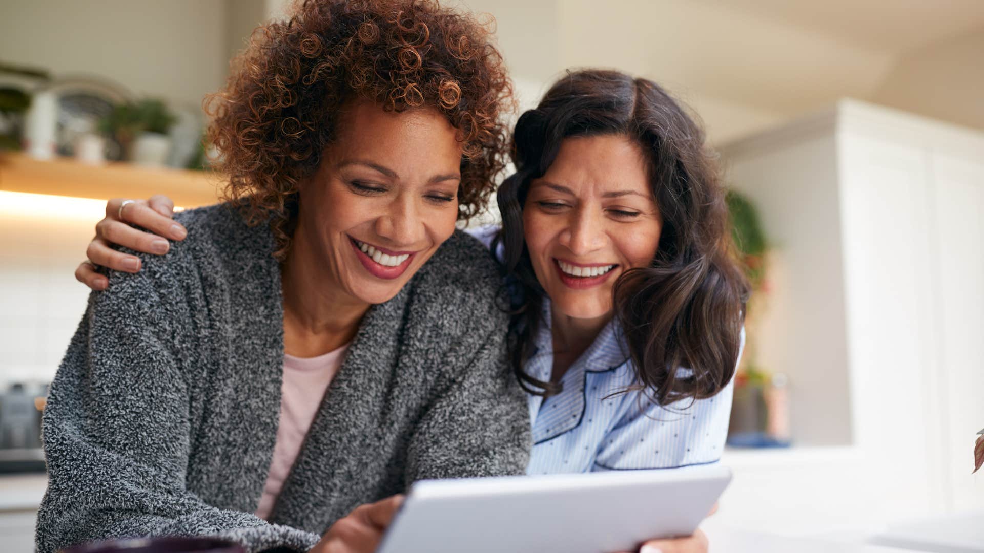 women smiling looking at a new technology device
