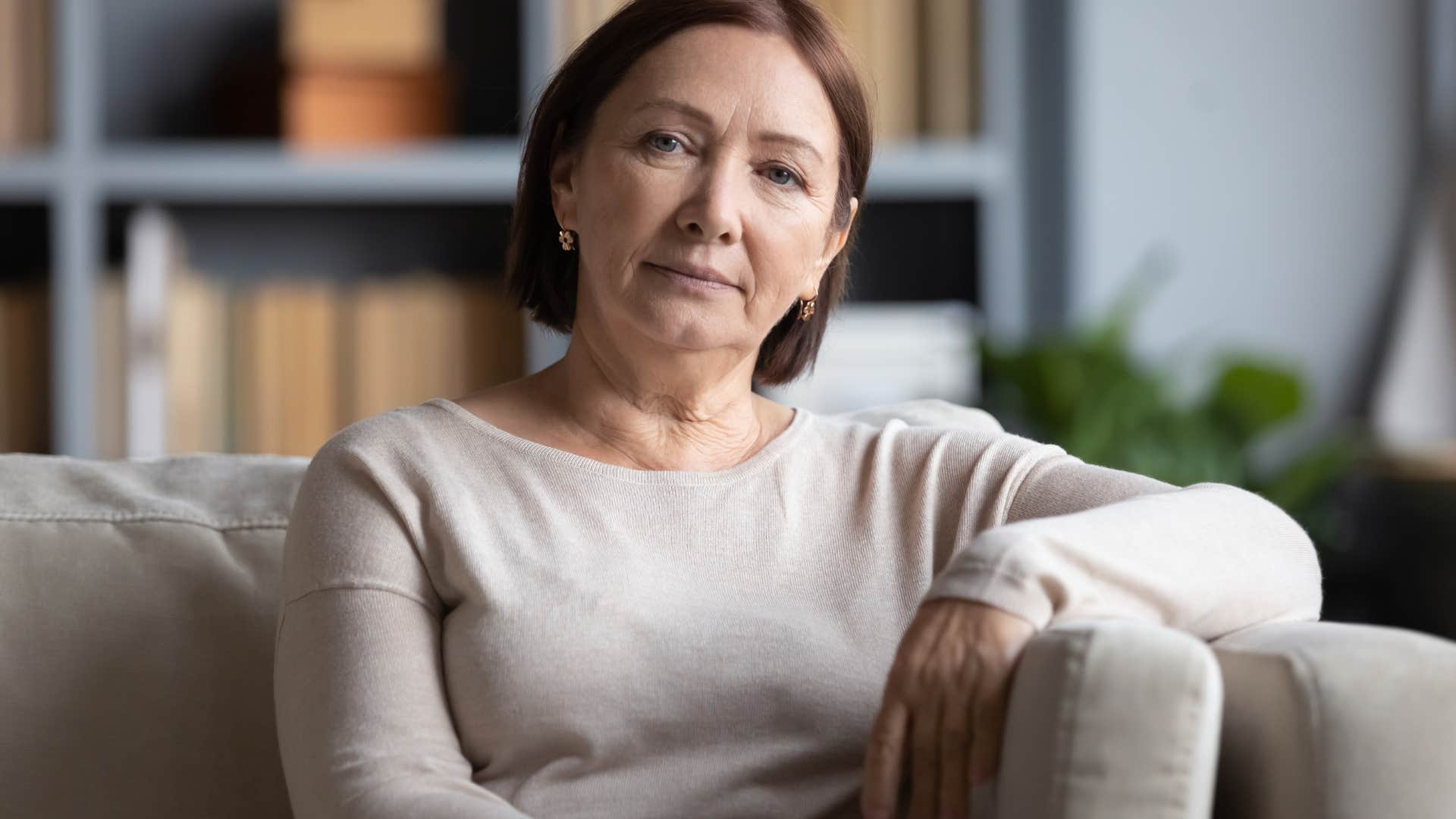 serious older woman sitting on couch
