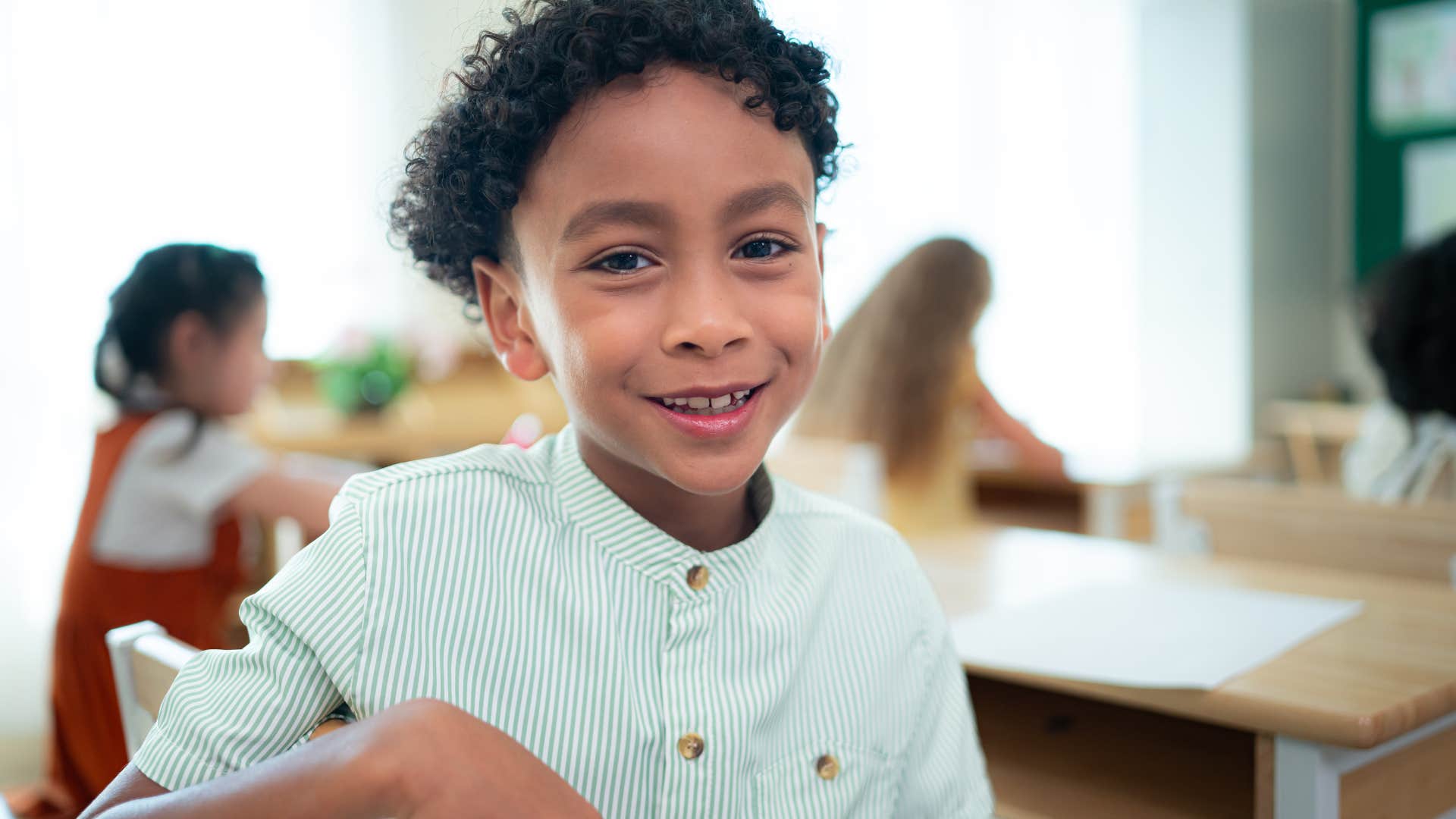kid who's an active listener smiling in a classroom
