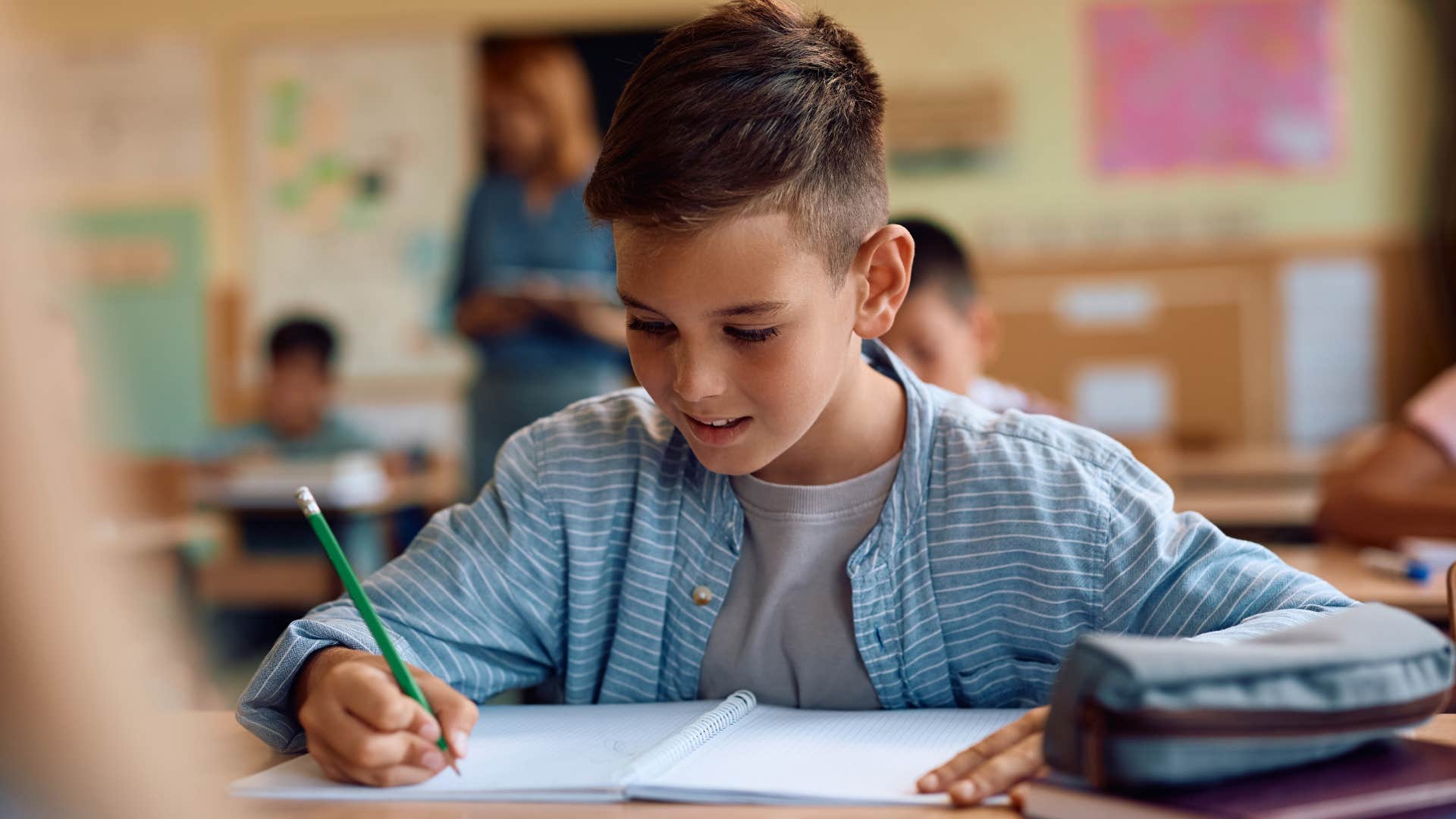 curious young boy doing work in a classroom