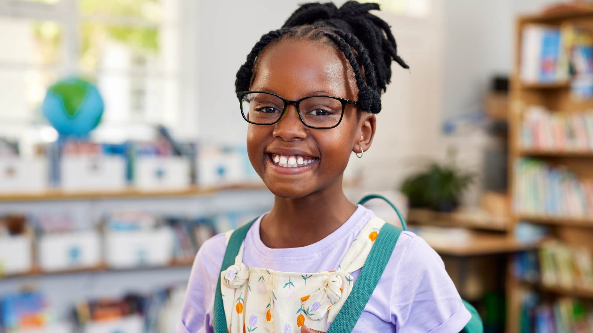 little girl who owns up to mistakes smiling with her backpack