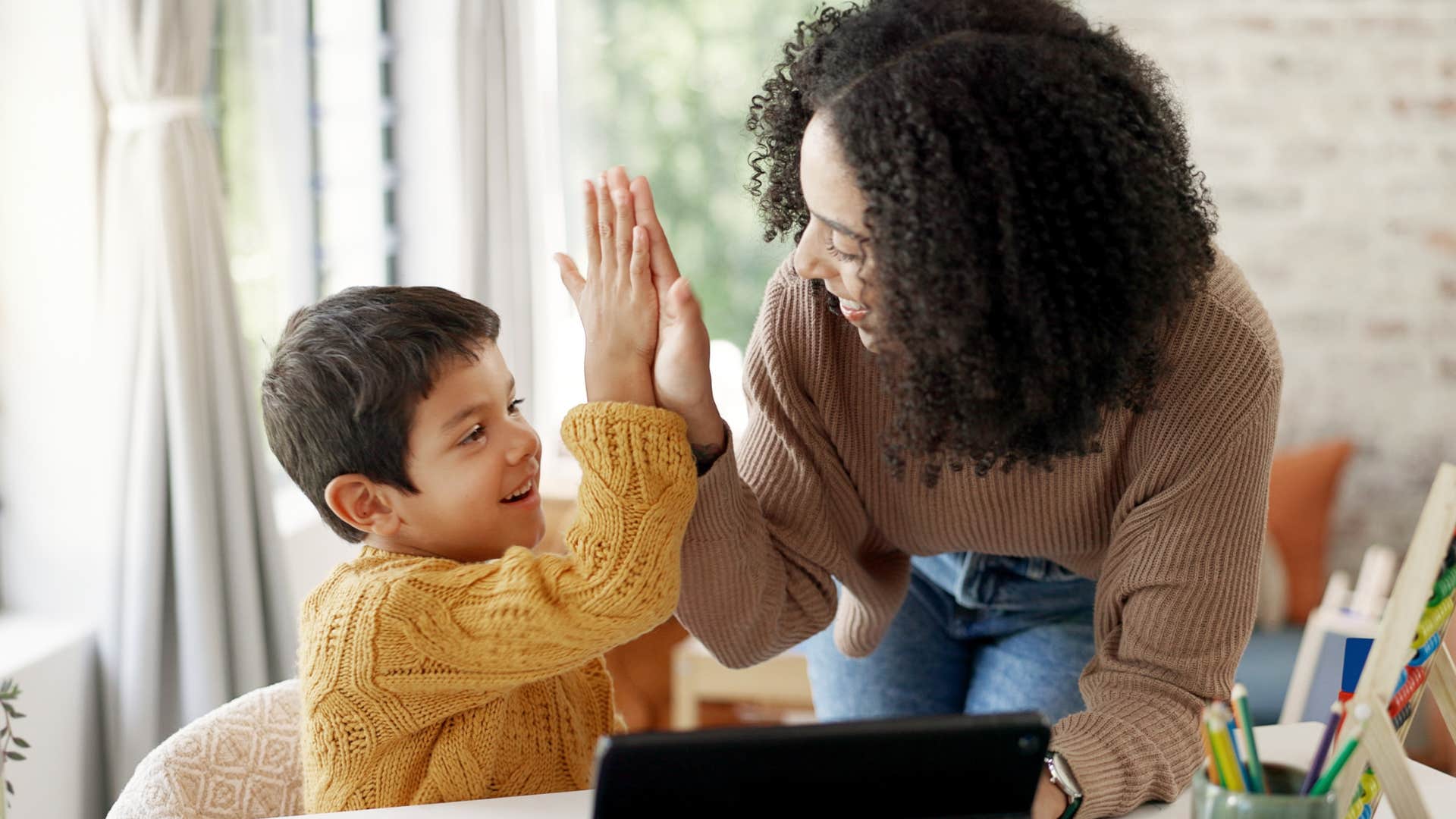 kid who takes pride in his work high-fiving his teacher